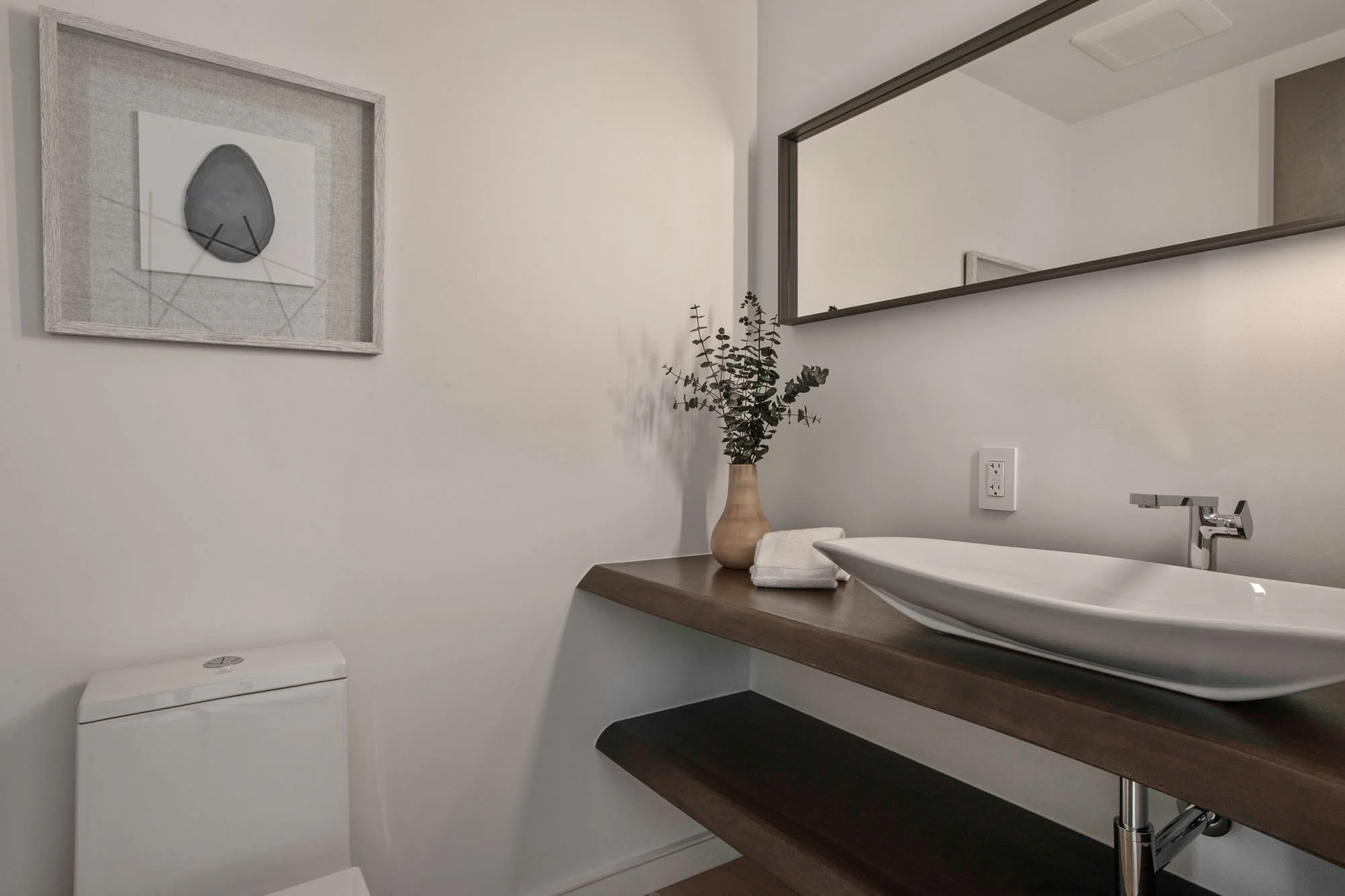 Designer powder room at 1647 Sanchez, San Francisco, featuring a modern white vessel sink, floating dark wood vanity, and minimalist abstract wall art in a luxury Noe Valley residence.