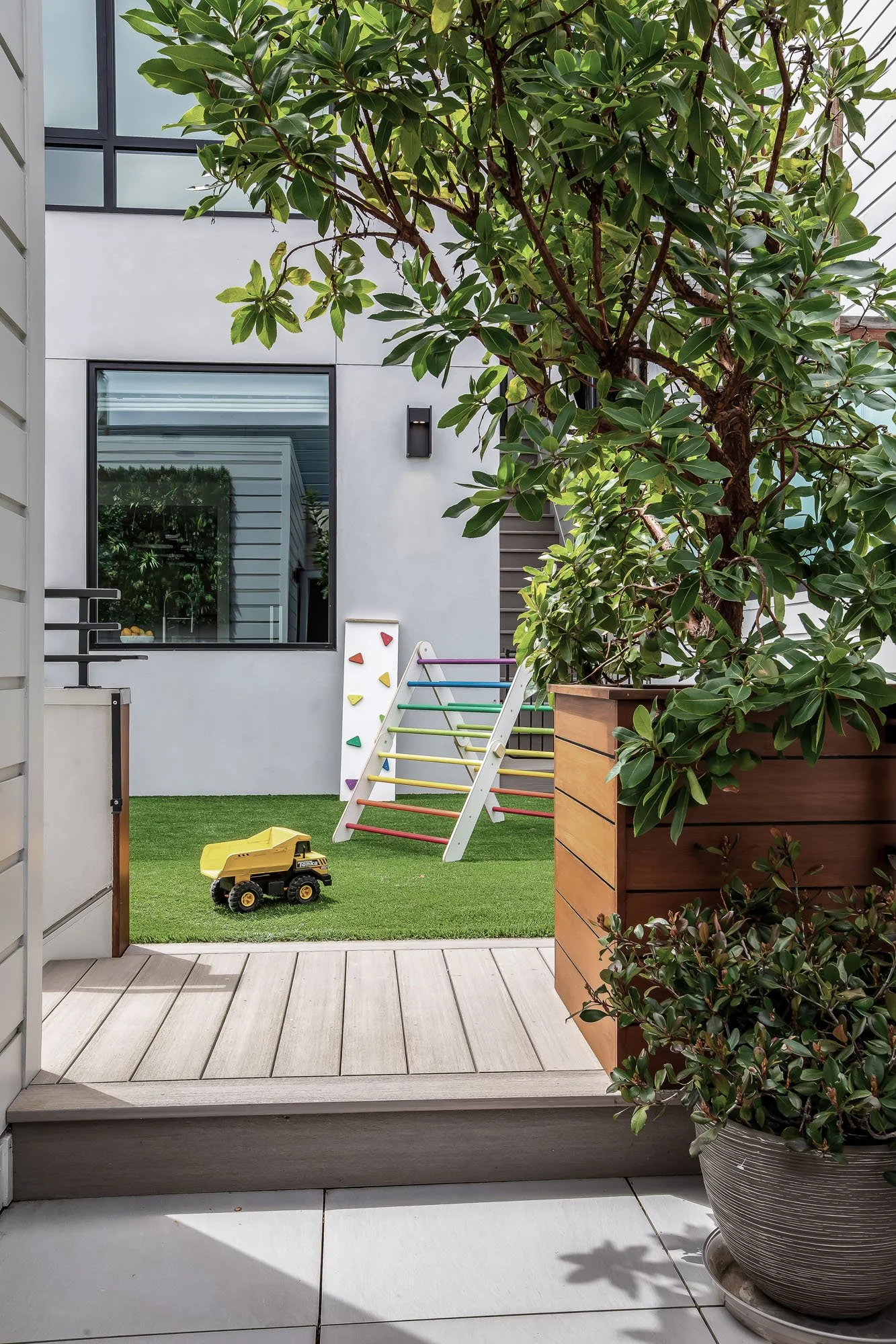 Family-friendly outdoor terrace at 1647 Sanchez with artificial turf, a children’s play area, and high-end Ipe wood planters.