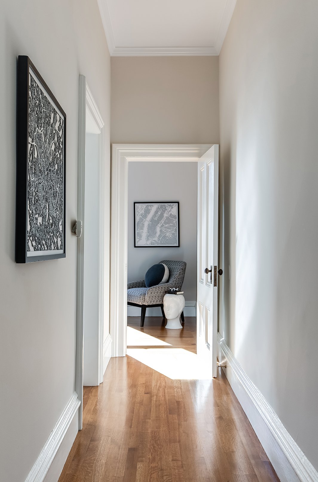 Elegant hallway in a luxury San Francisco home featuring polished hardwood floors, high ceilings, and designer art leading to a cozy reading nook.