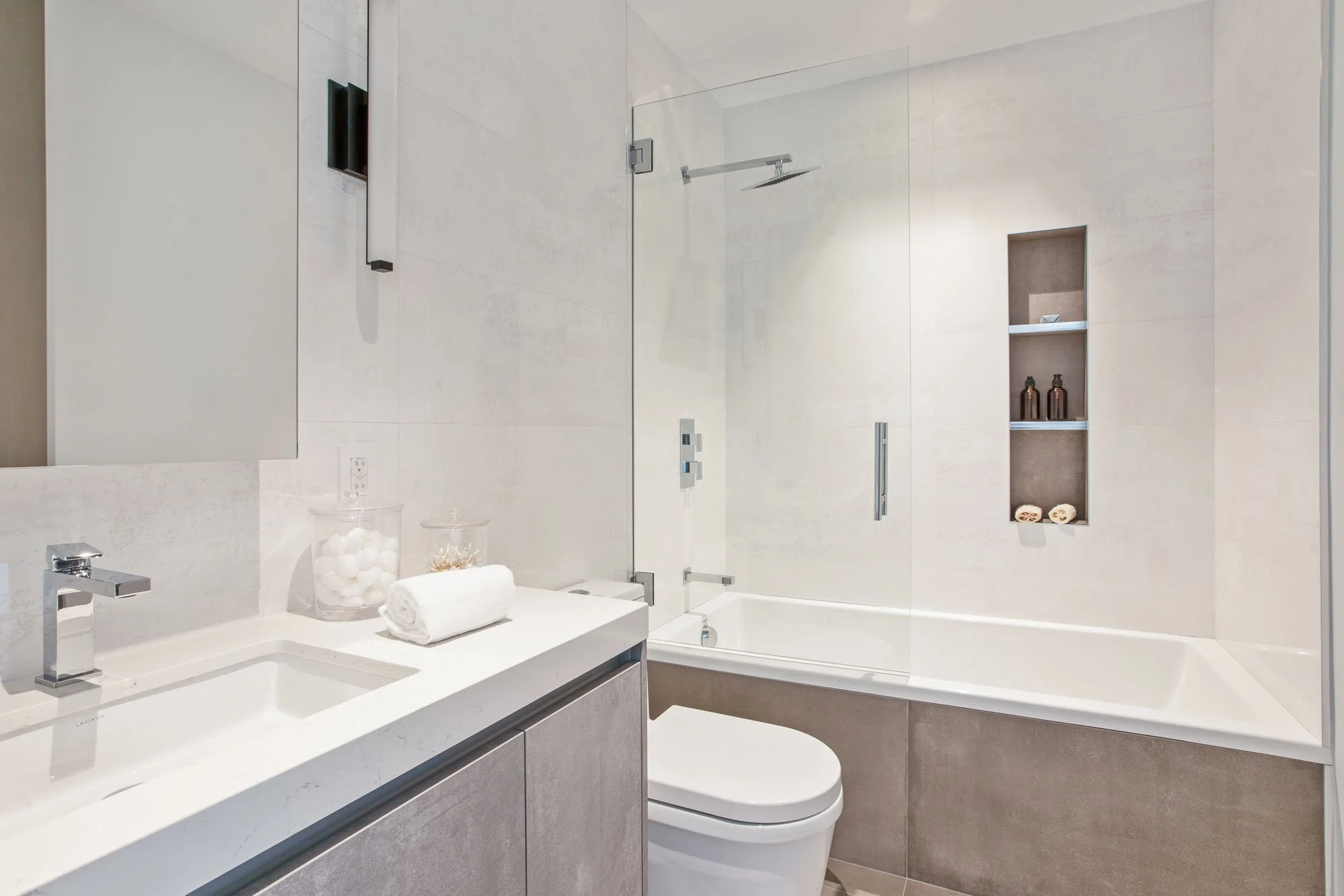 Contemporary bathroom with a deep soaking tub, frameless glass shower partition, and custom recessed shelving in an $8M San Francisco luxury home.