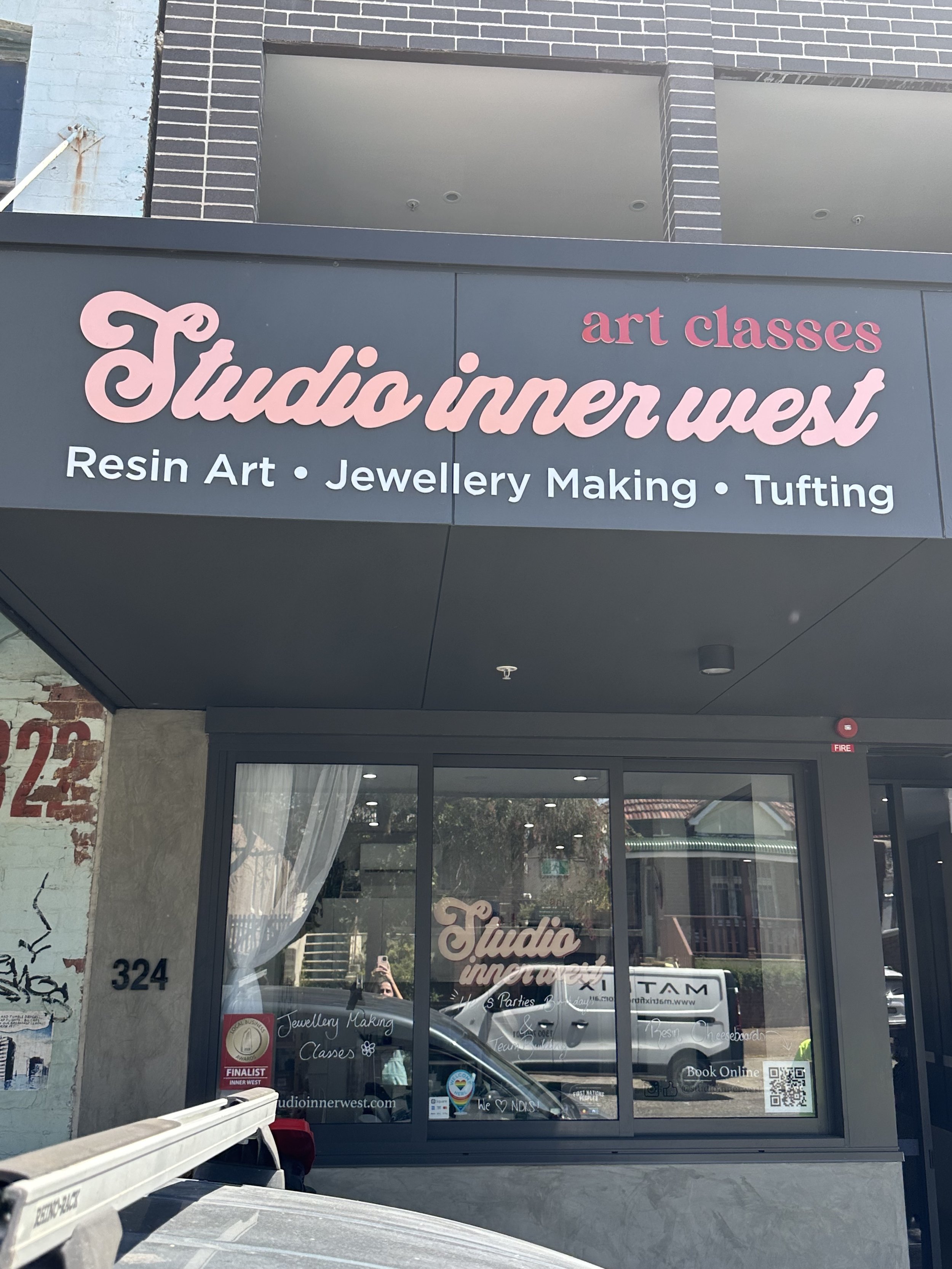Sign for "Studio Inner West" offering art classes including resin art, jewelry making, and tufting, located at 324.