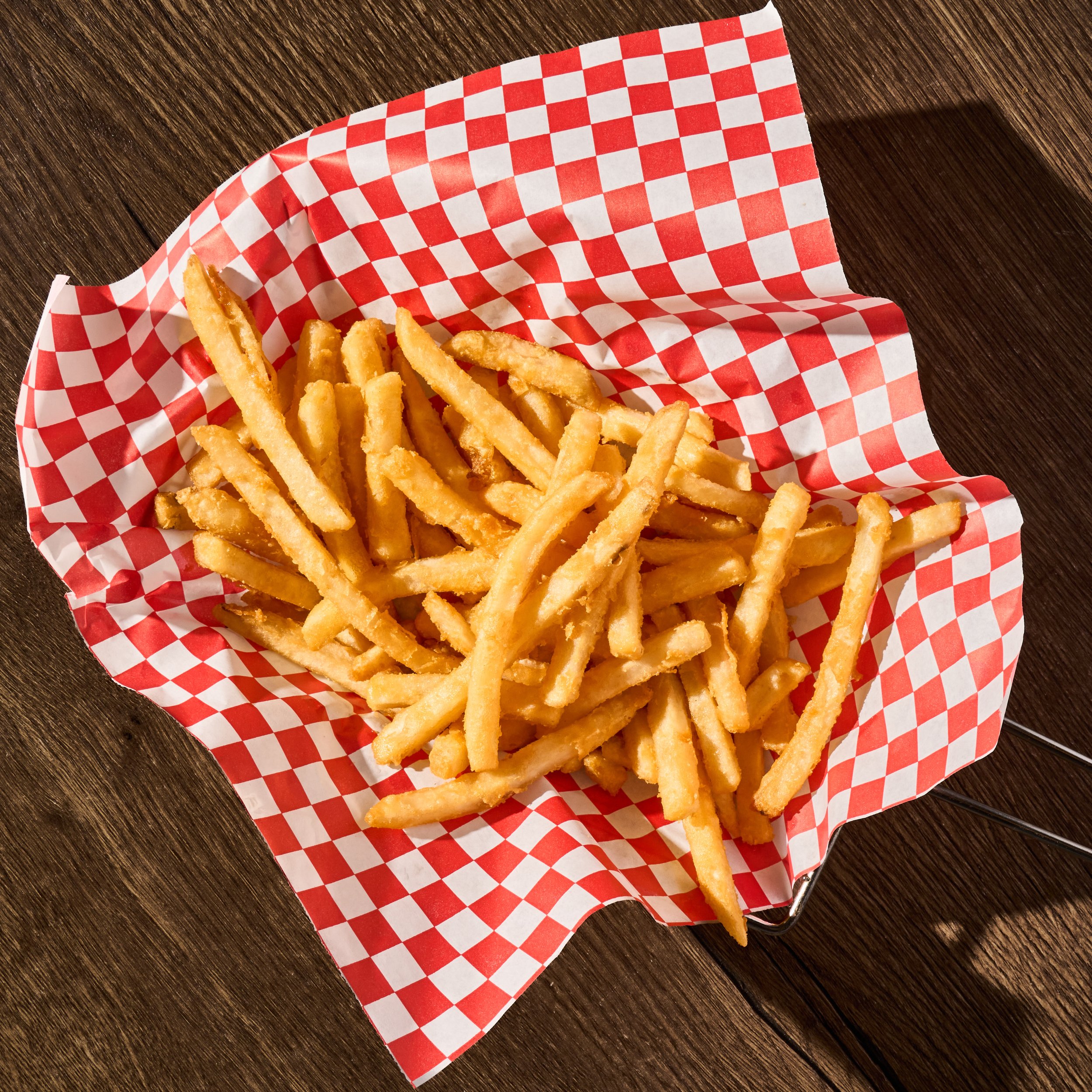 Basket of French fries on red and white checkered paper