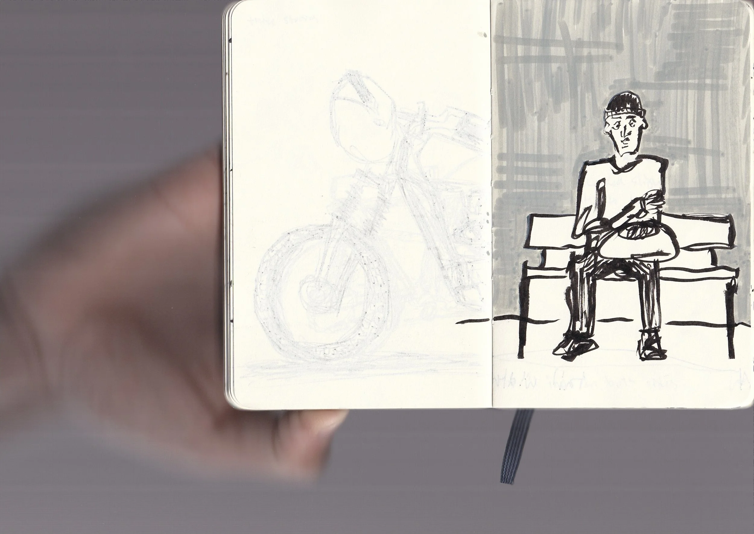Sketch of a person sitting at a table, crossed arms, wearing glasses and a headband, with a bicycle illustration on the left page.