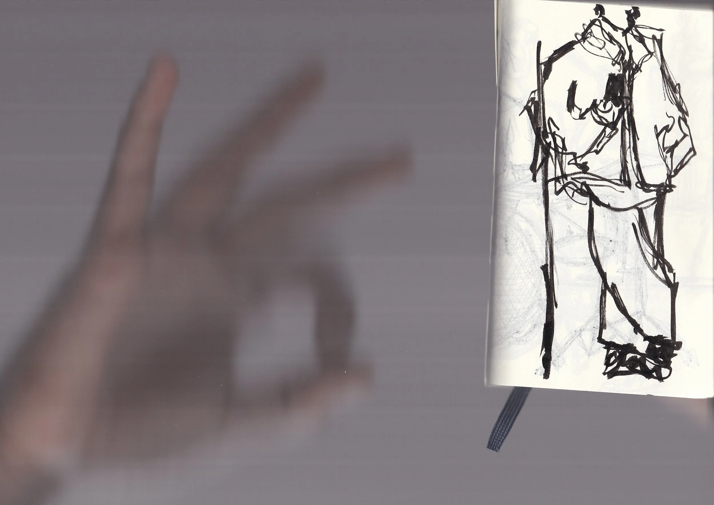 A sketch of a woman standing with her hand on her hip, drawn with bold black lines on paper.