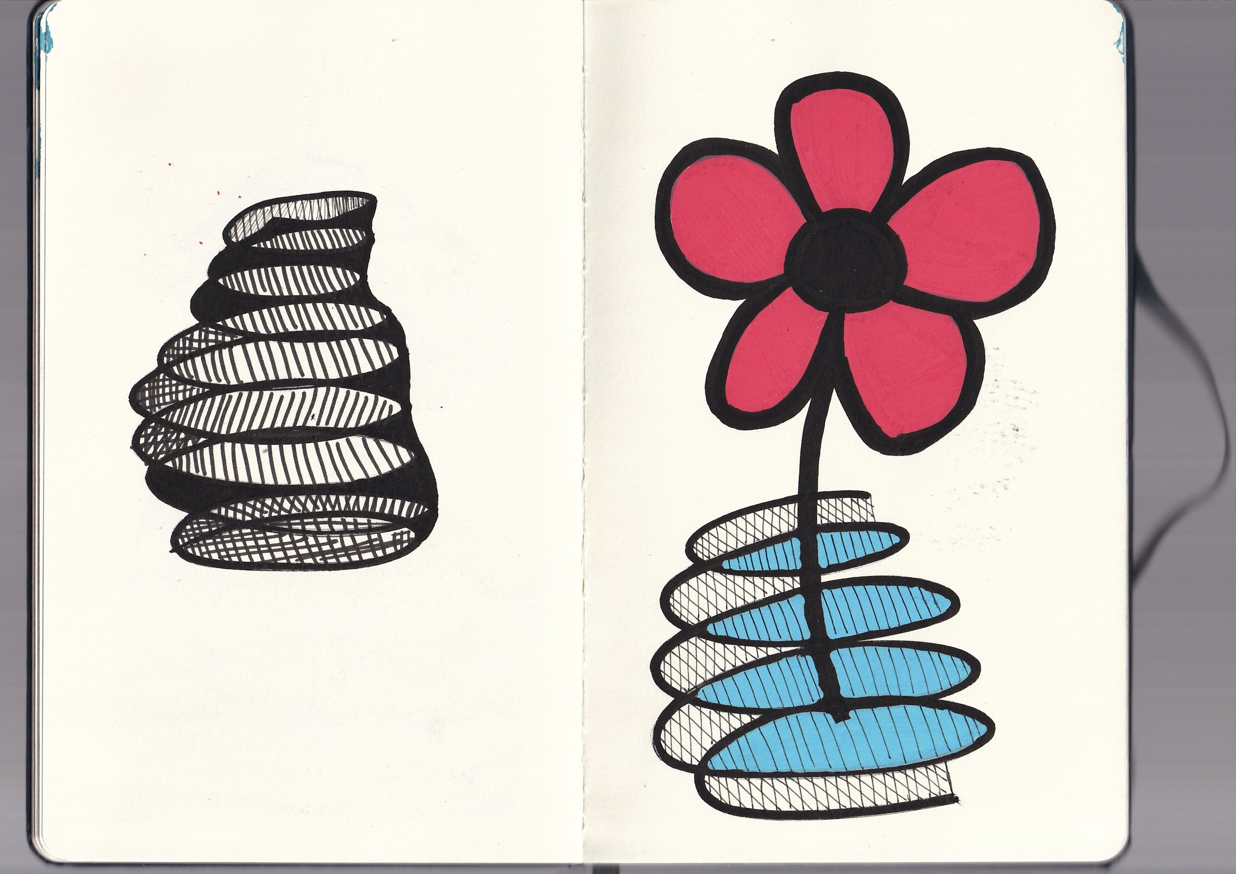 Drawing of two abstract spiral coil structures on a white background, one on each page of an open book, with one coil in black and the other in blue and black, and a large pink flower with black outline on the right side.