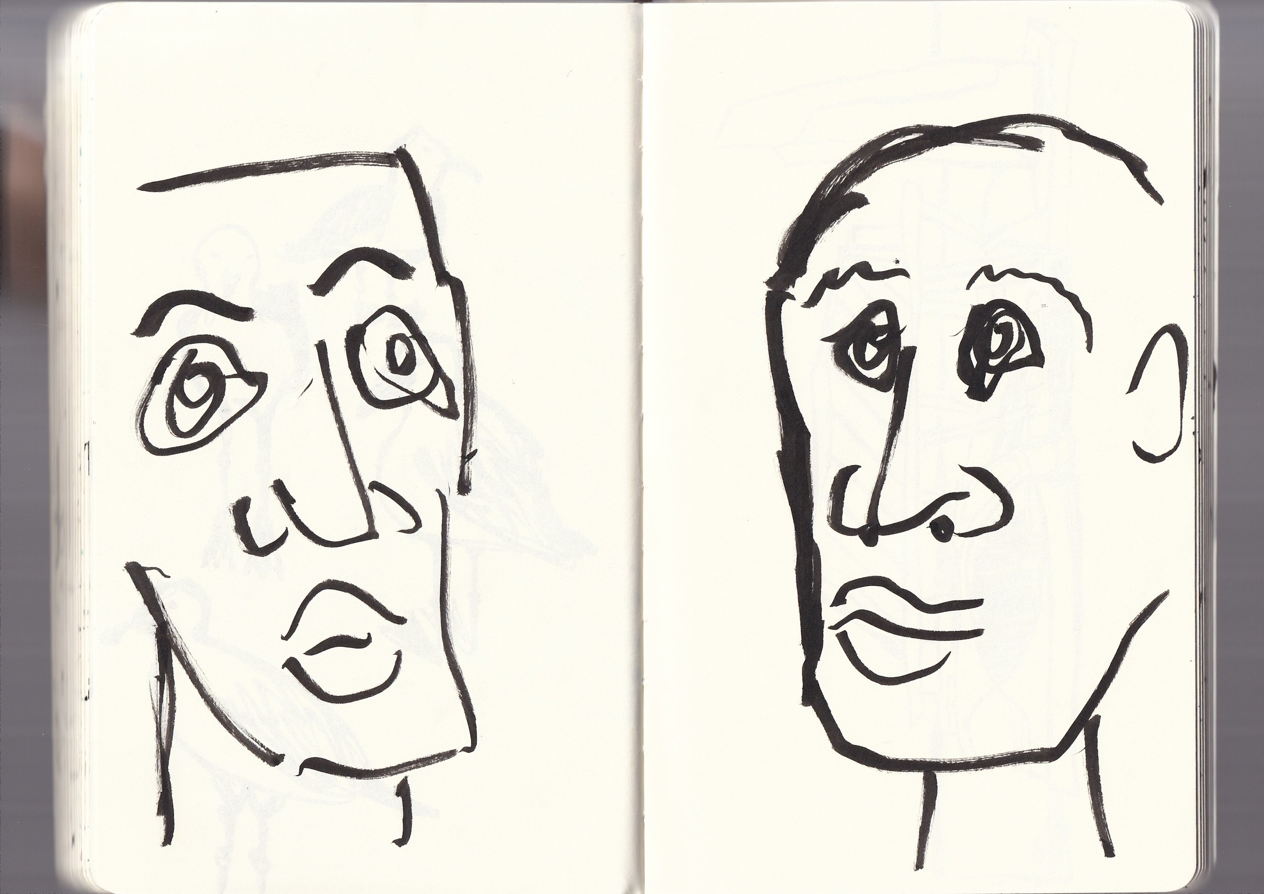 A black ink sketch of two smiling faces, drawn with simple lines and minimal detail, on a white background.