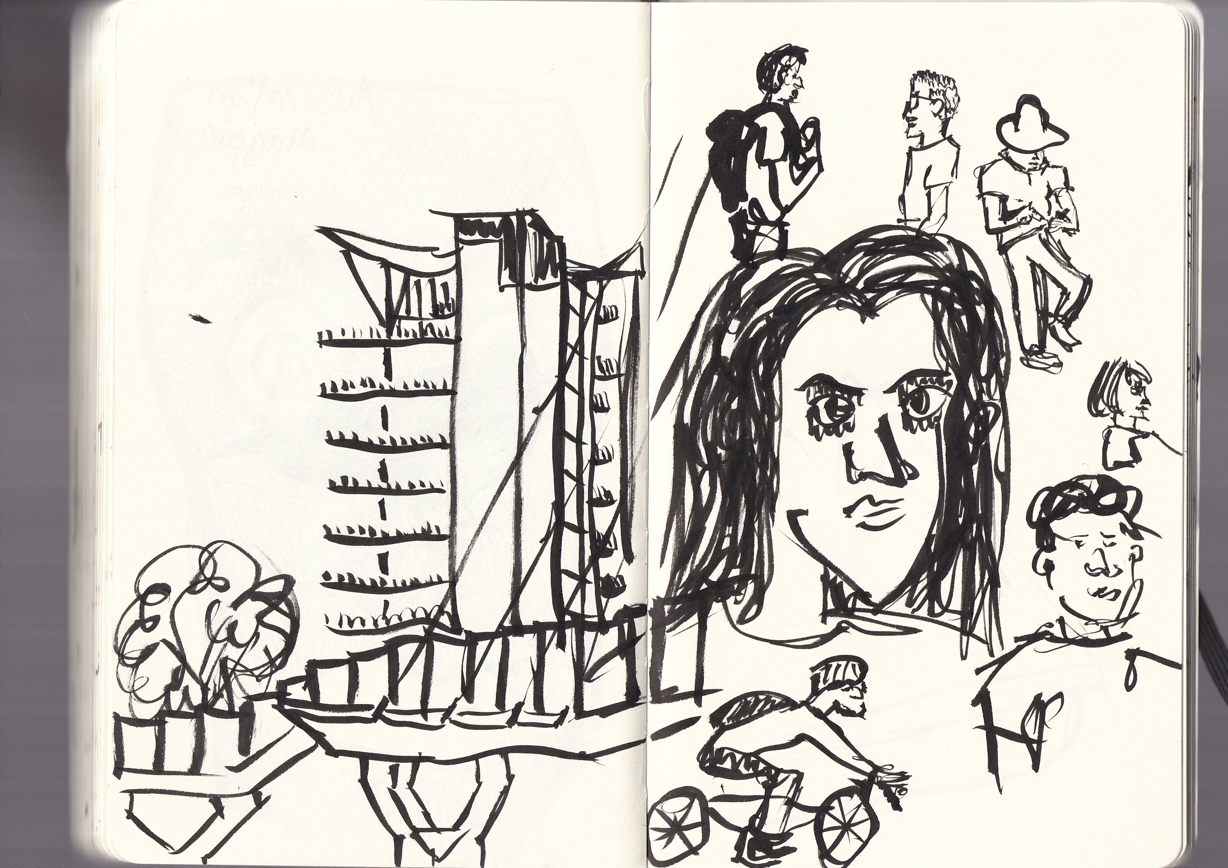 A black ink sketch of various people and building structures. Includes a large portrait of a woman with long hair, several smaller people, one riding a bicycle, and others walking. A building with multiple floors and antennas is also depicted.