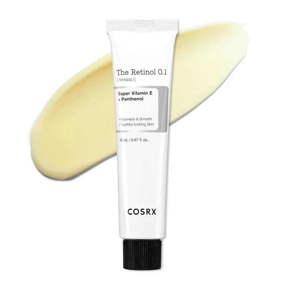 A tube of COSRX The Retinol 0.1 cream with a smear of yellow and white cream behind it.