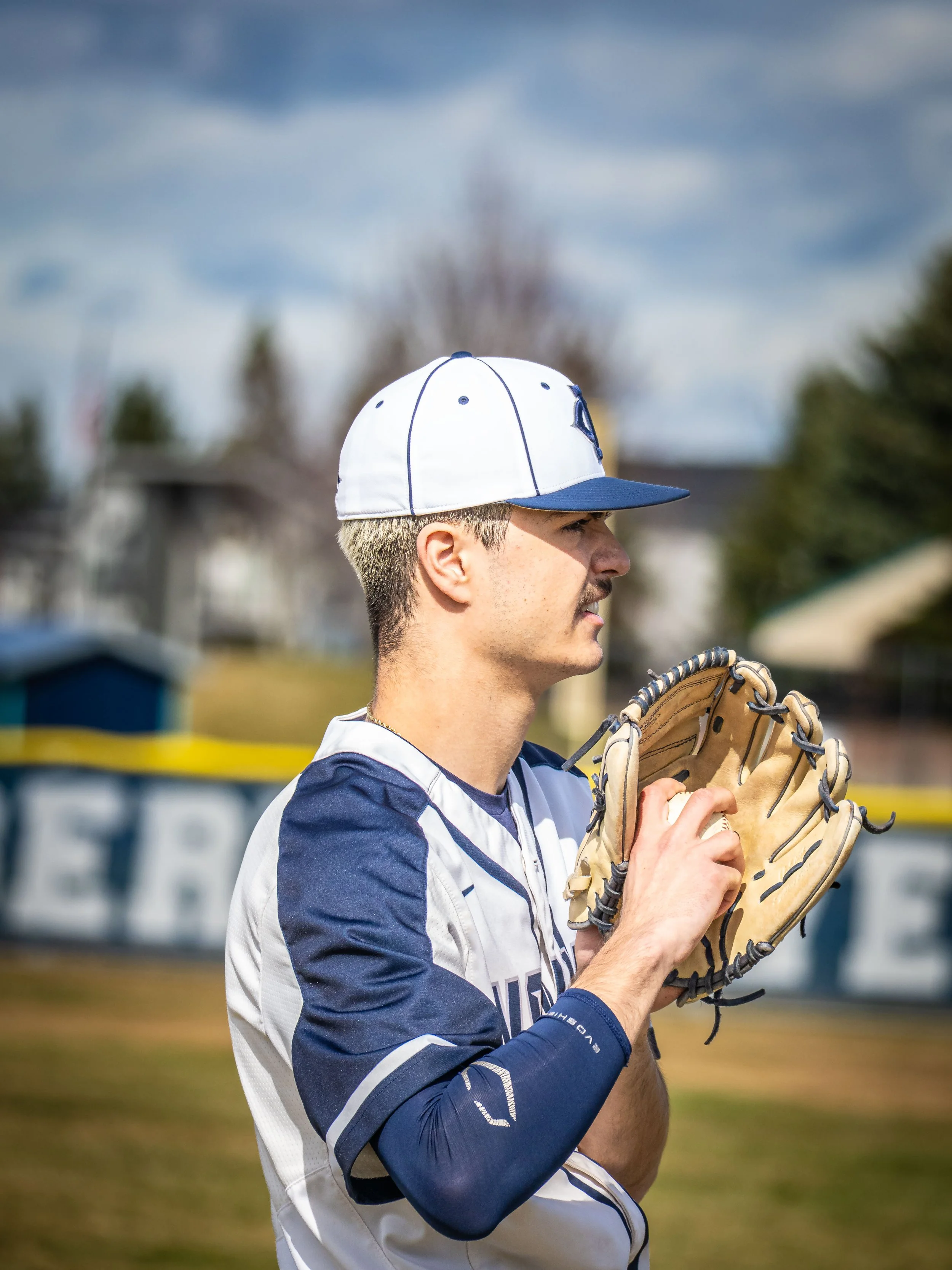 Baseball player in blue and white uniform holding a glove