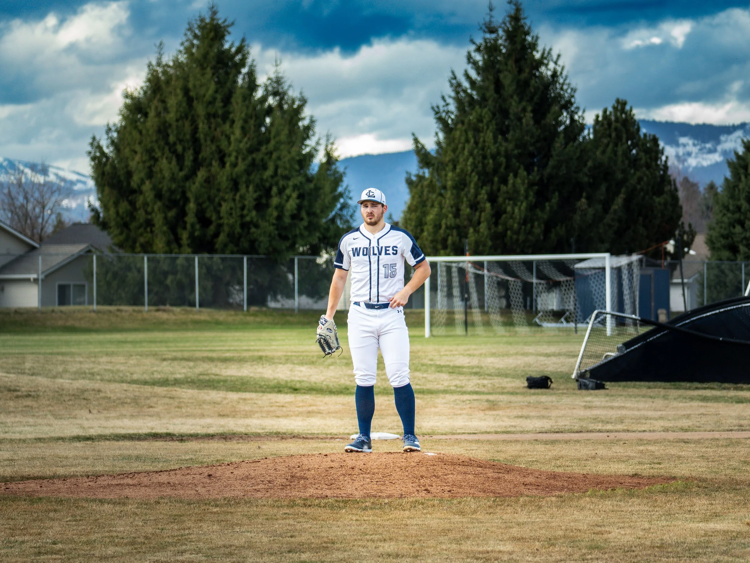 Baseball player in white uniform on pitcher's mound with glove