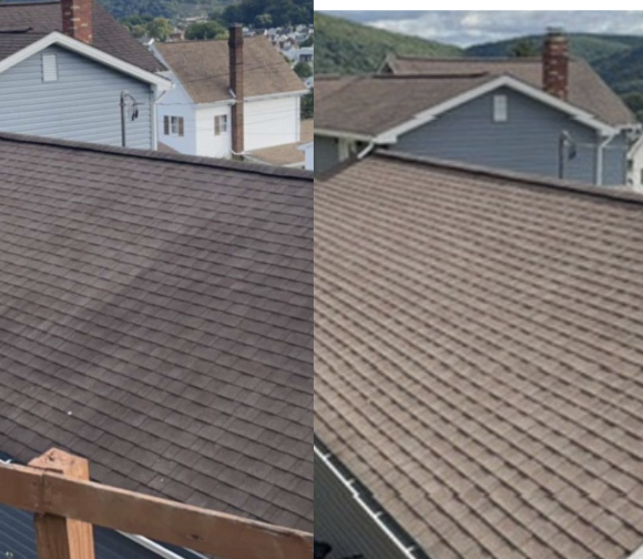 Side-by-side comparison of a house roof before and after cleaning or replacement, showing a darker, stained roof on the left and a cleaner, lighter roof on the right, with neighboring houses and a hilly landscape in the background.