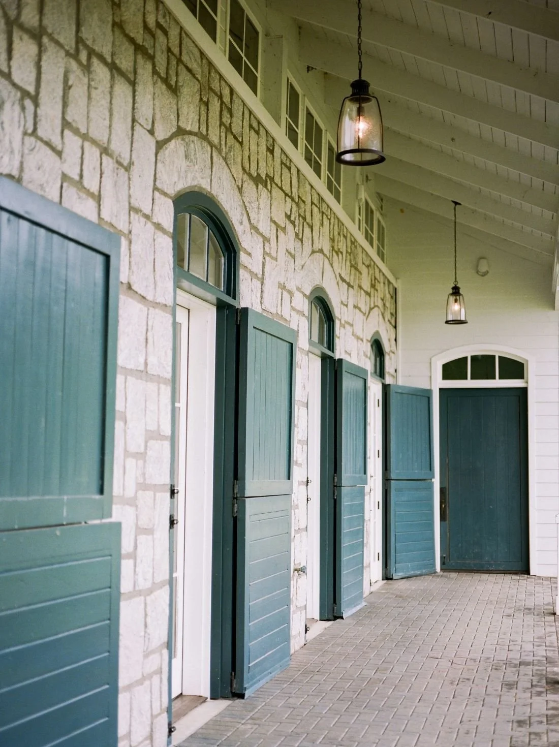 Stone sided barn with nicely placed pendant lights under the overhang