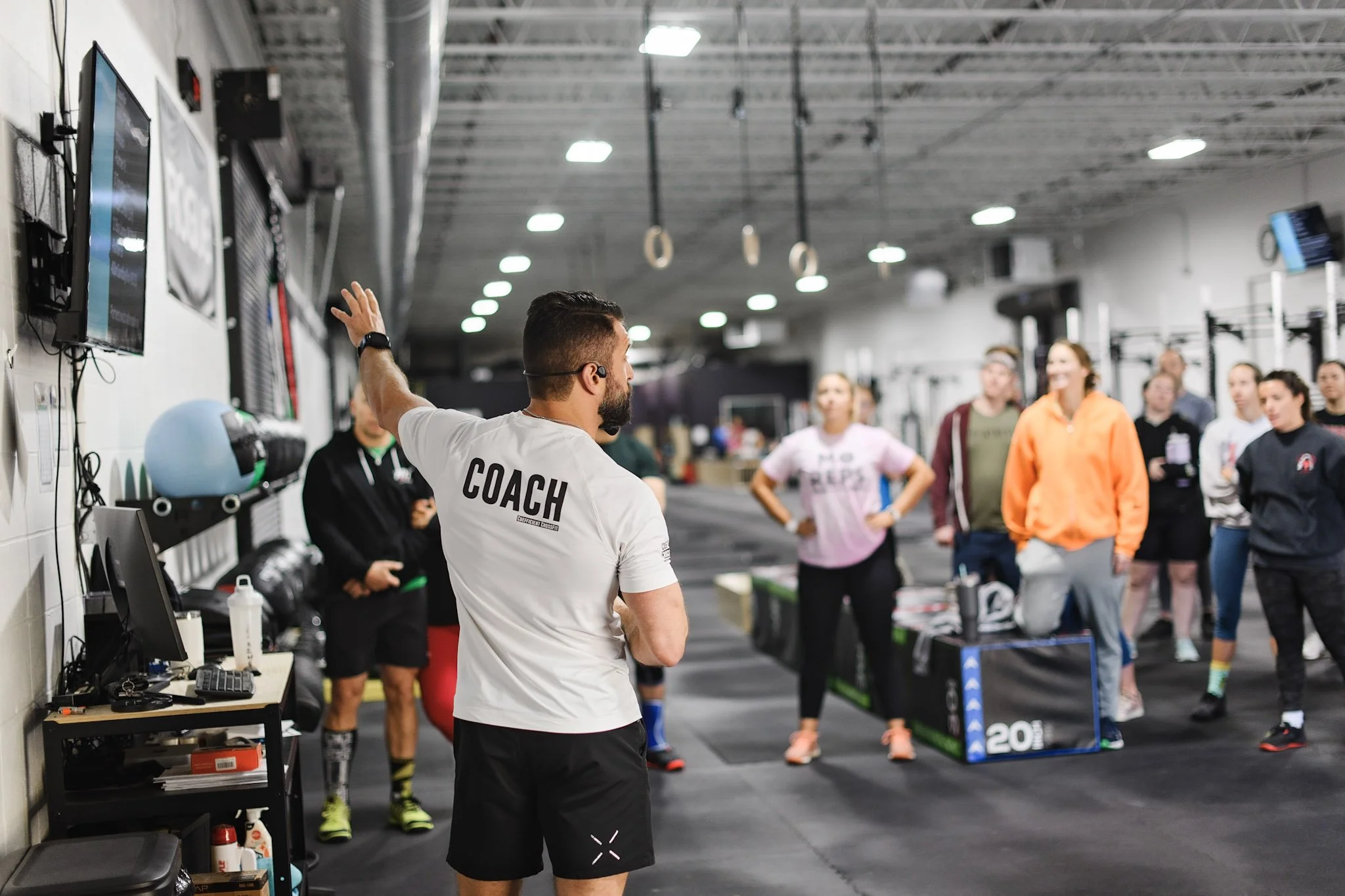 A coach briefing a big group before a Saturday community workout