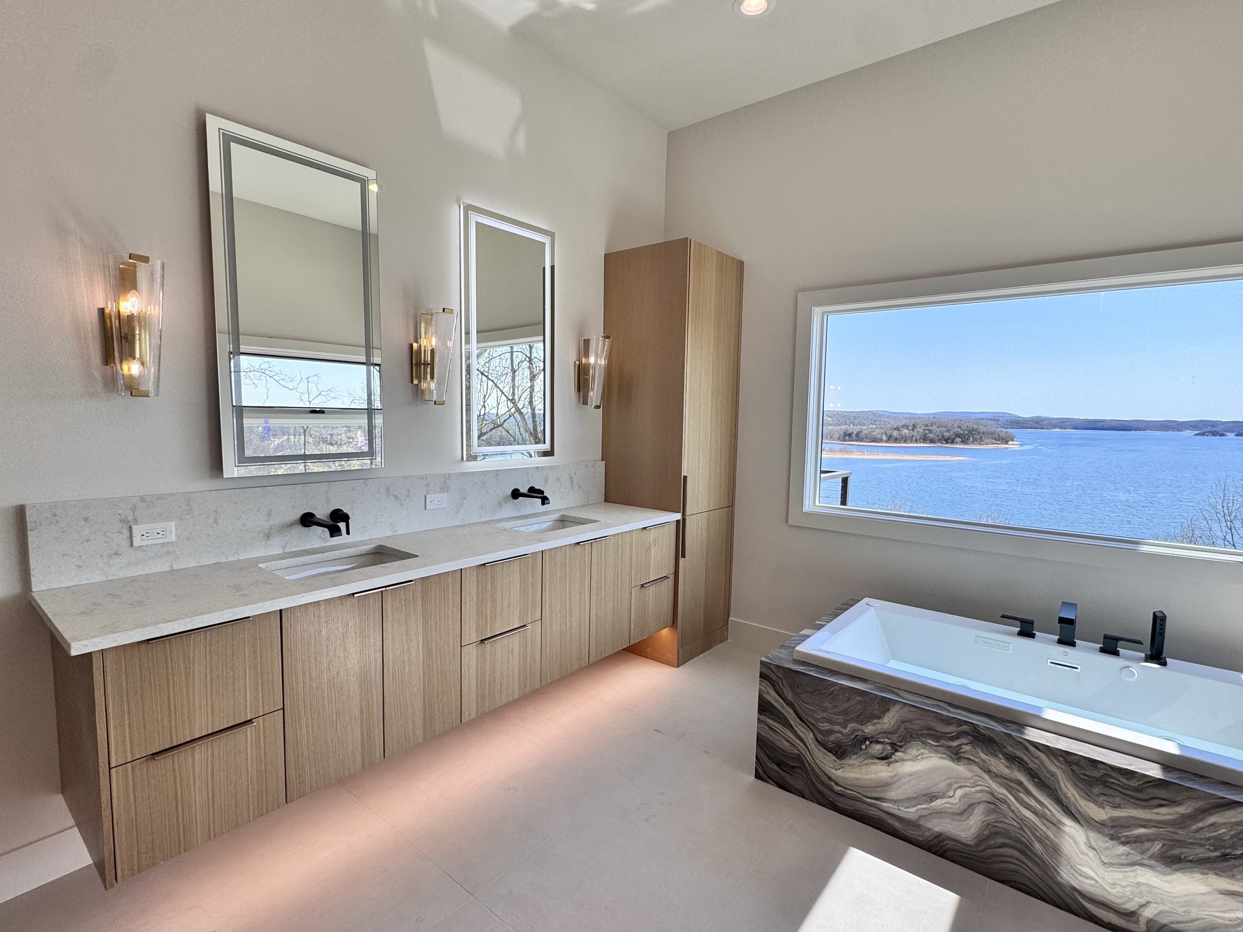 white oak rift floating vanity cabinets with view to the lake by the bathtub
