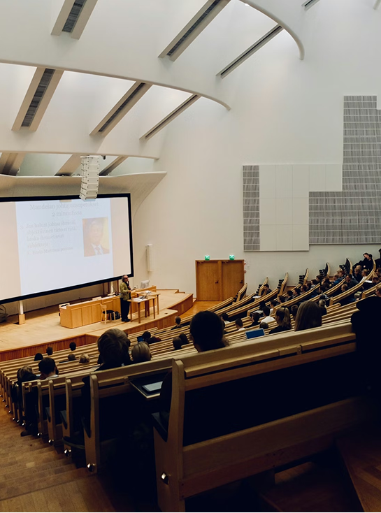 Audience in a lecture hall listening to a presentation with a large screen. This image highlights Richelle Kokol's, expertise in Public Speaking - educational, insightful programs tailored for appraisers, collectors, organizations, and institutions.
