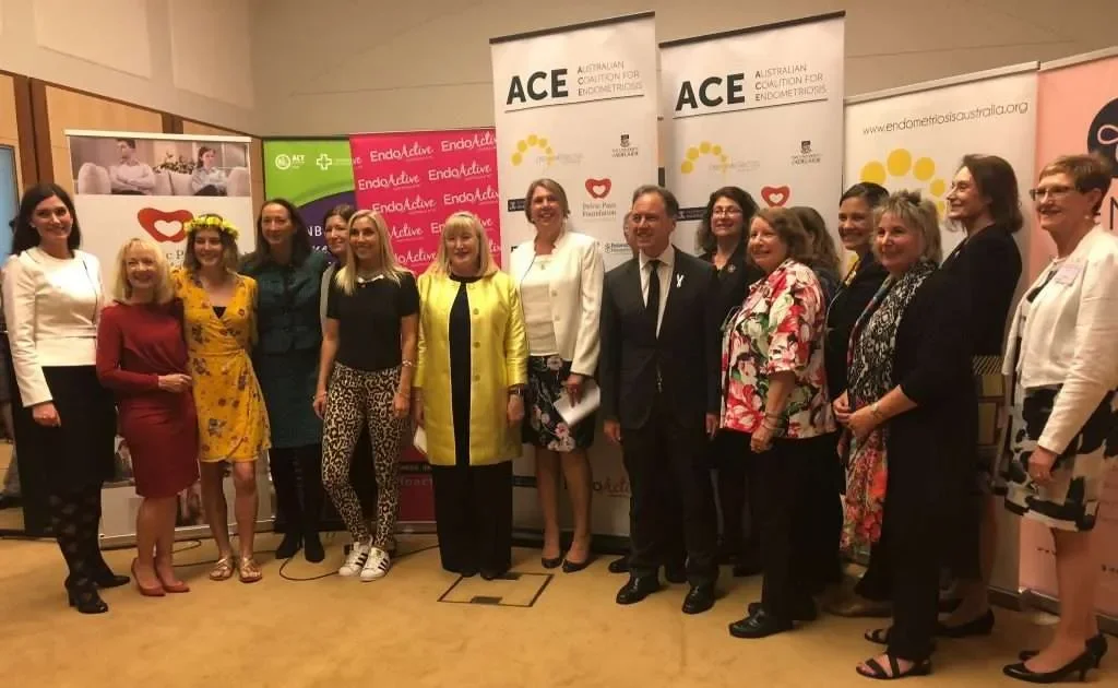 Group of professionals at a conference or event, standing in front of banners for ACE, EndoActive, and other health organizations.