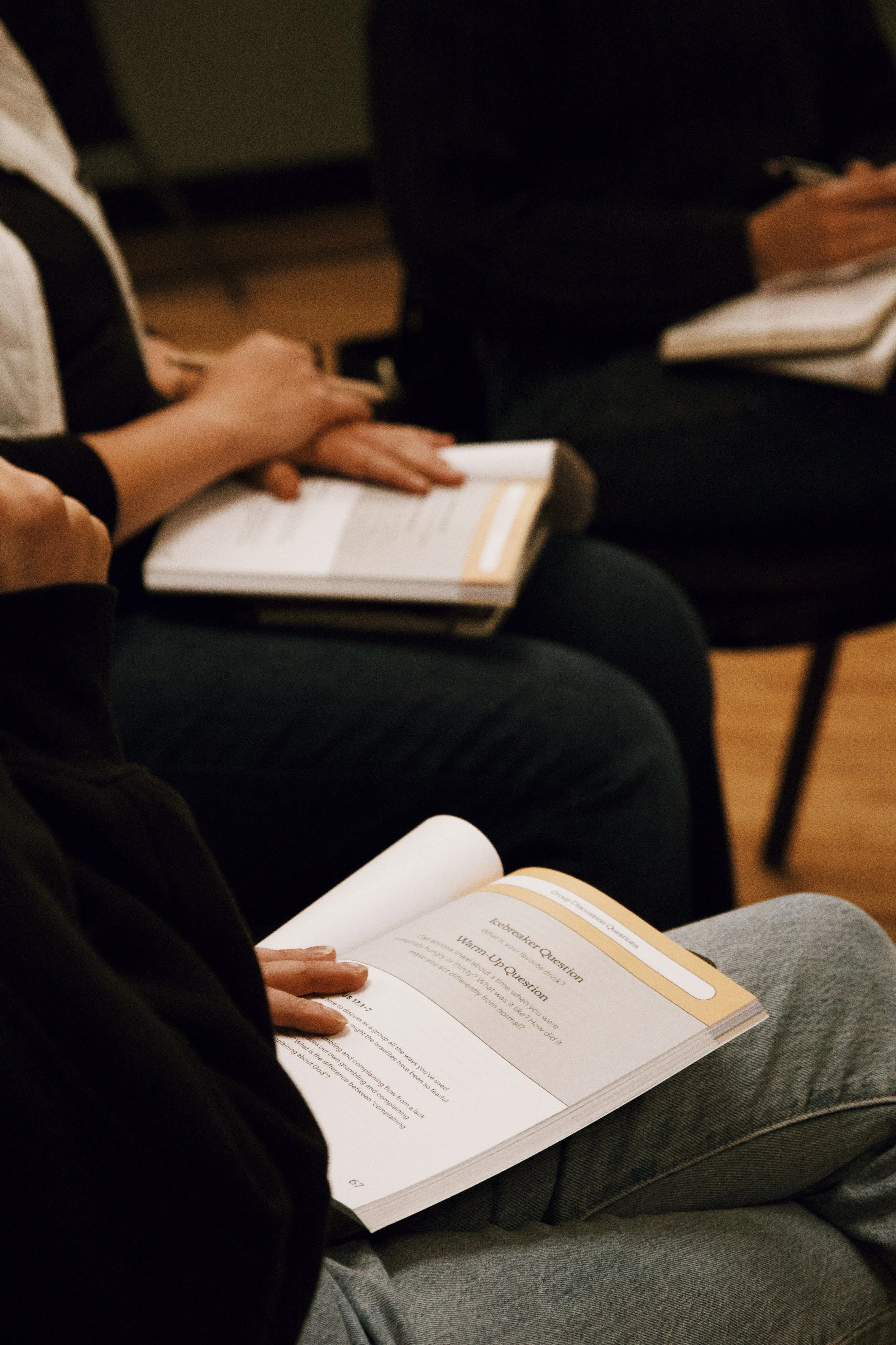 People sitting and reading booklets during a class or seminar.