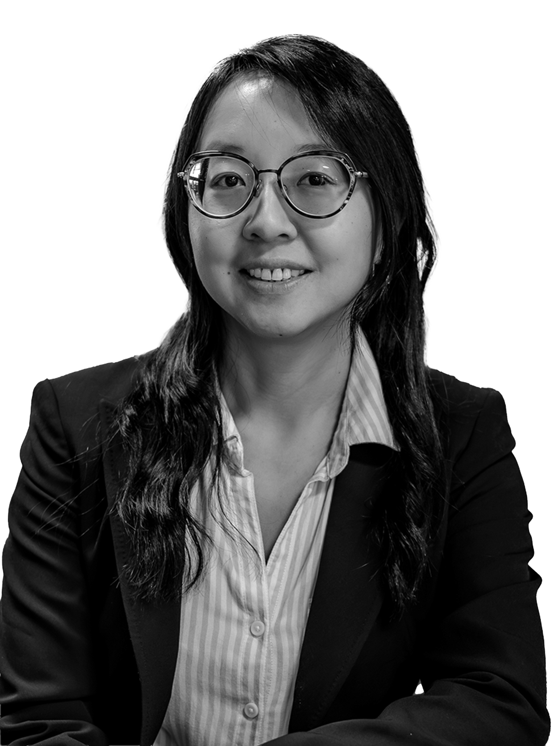 Black and white portrait of a woman wearing glasses, a striped shirt, and a blazer, smiling at the camera.