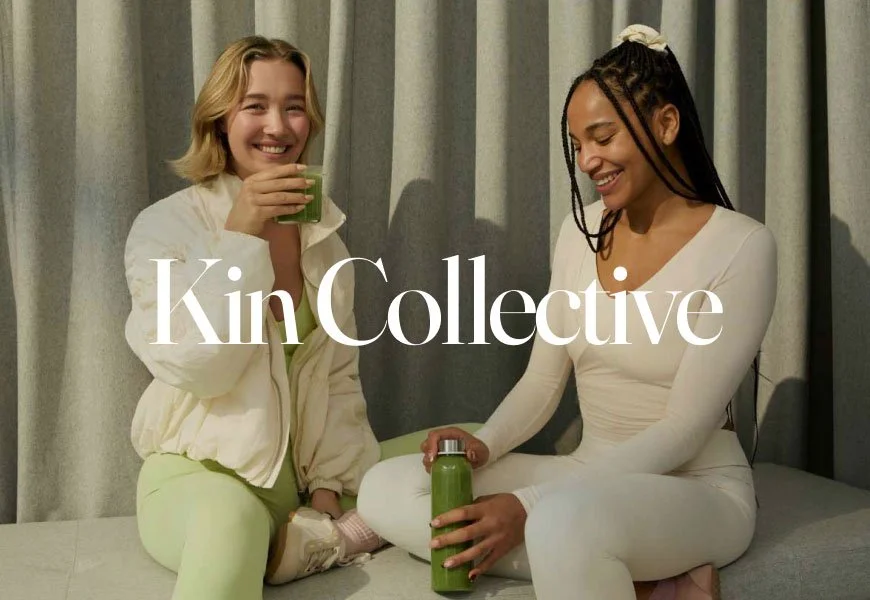 Two women wearing cream and light green fitness clothes while smiling and drinking juice and water