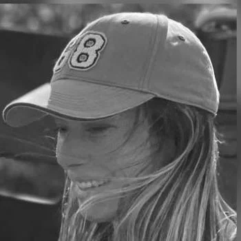 Frau mit Baseballkappe, lächelnd, Schwarz-Weiß-Foto