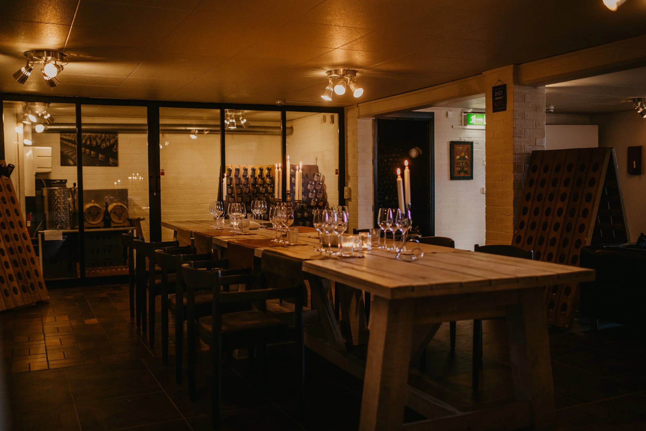 Ett dukat middagsbord i ett mysigt restaurangrum med stearinljus och vinglas.