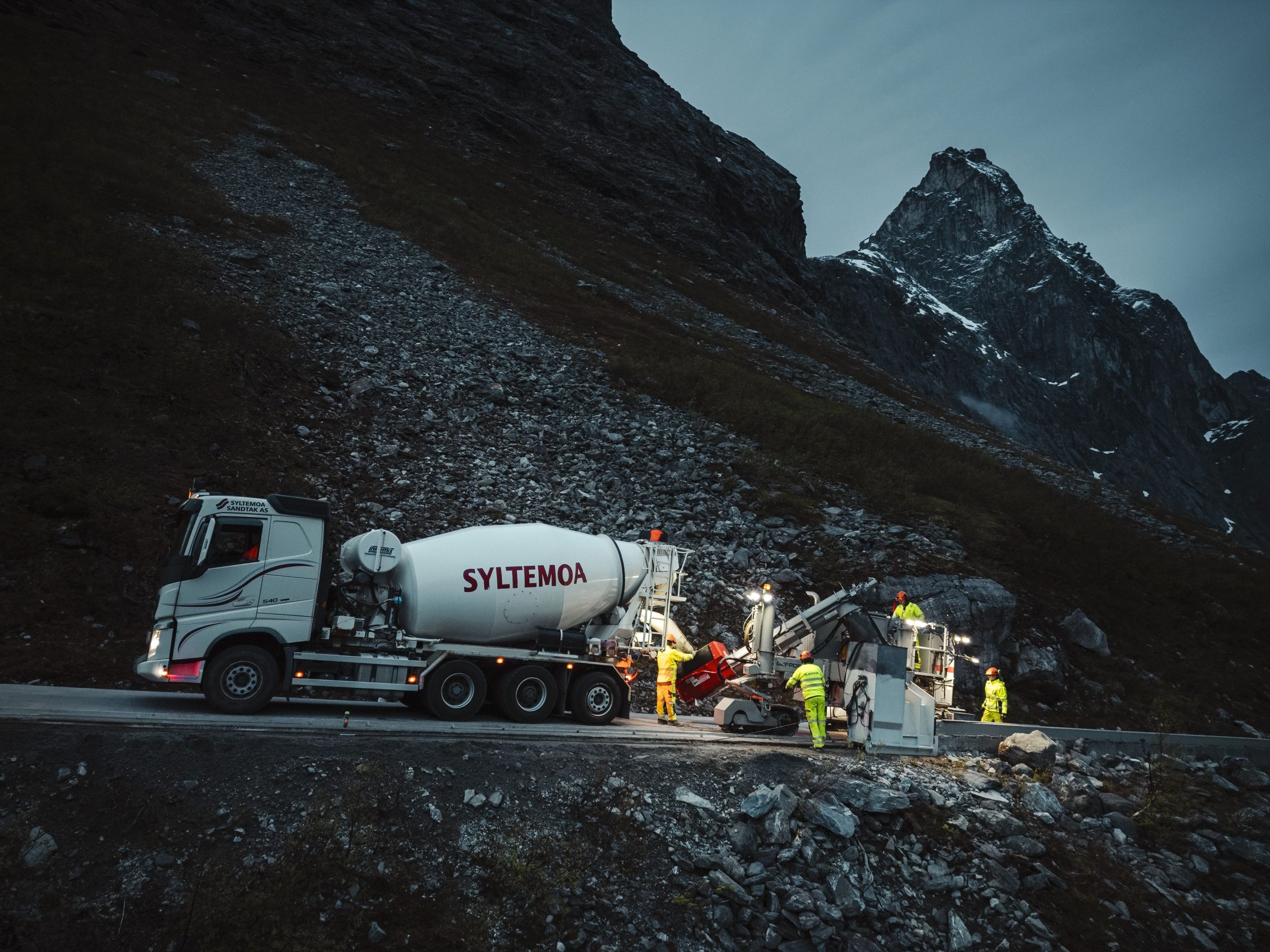 Foto av betonglaget til Arvid Gjerde som monterer betongrekkverk på Trollstigen