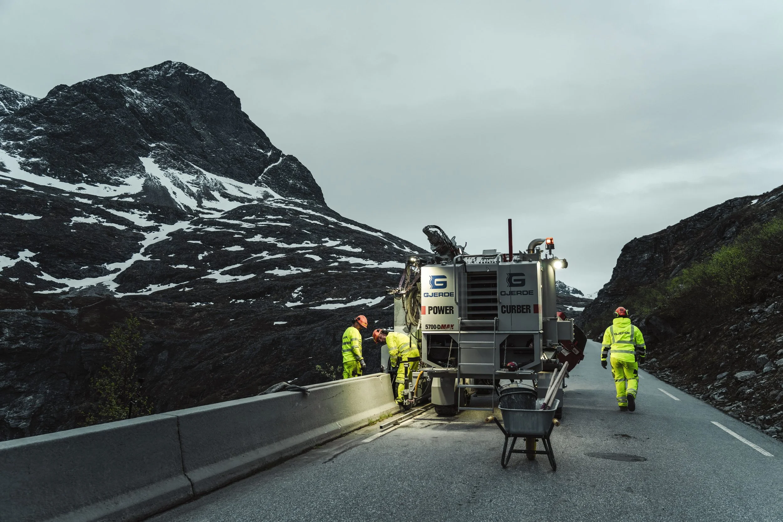 Foto av betonglaget til Arvid Gjerde som monterer betongrekkverk på Trollstigen