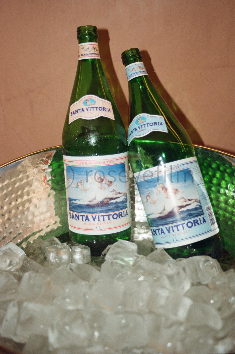 Two bottles of Santa Vittoria mineral water in a bowl of ice cubes.