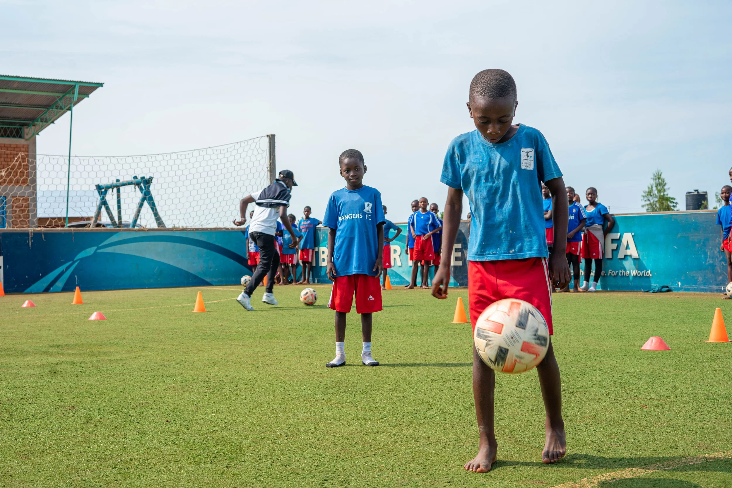 Local youth playing soccer on a field. 