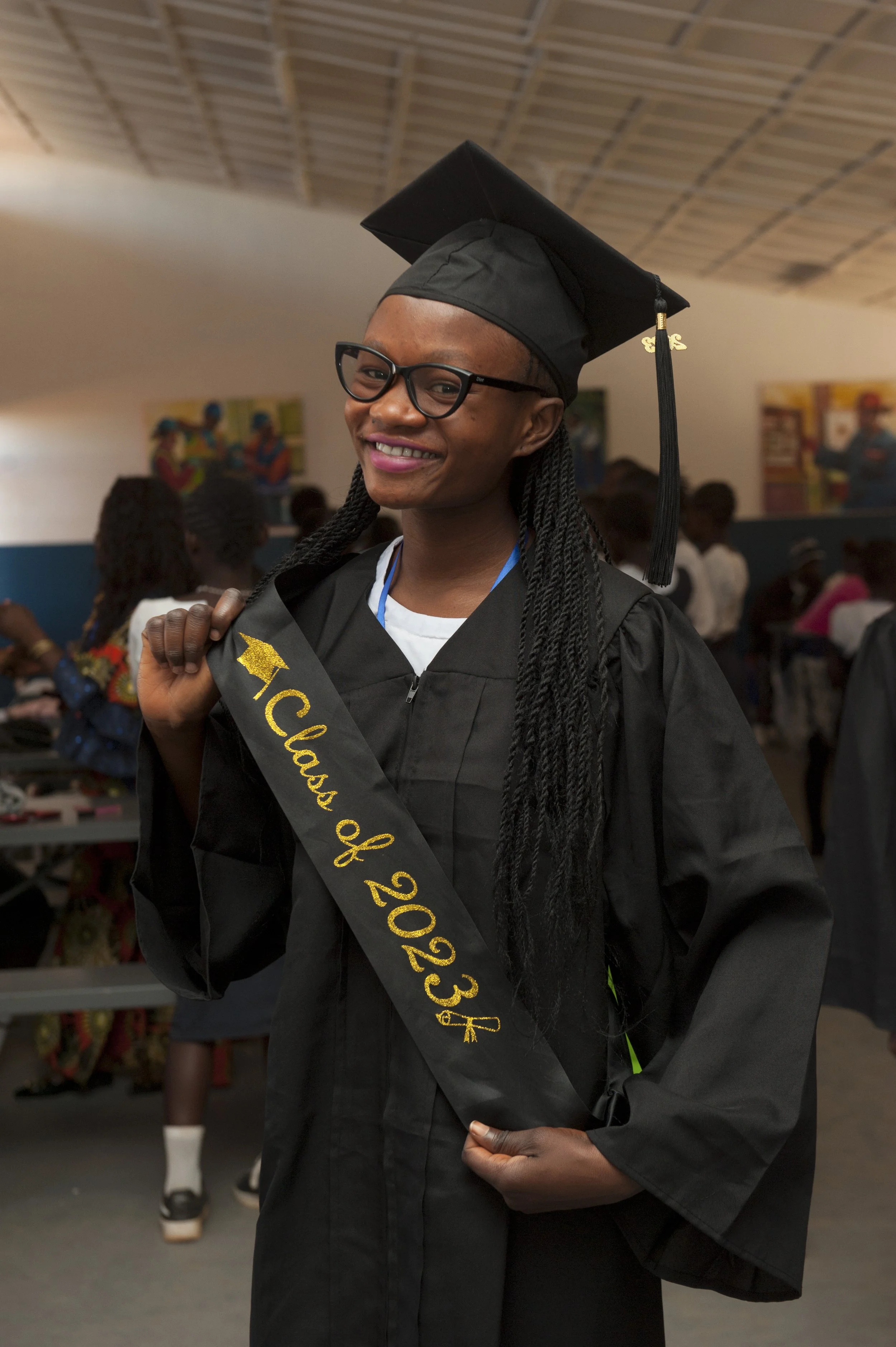 Louise at the age 18 smiling at the camera with a graduation outfit on.