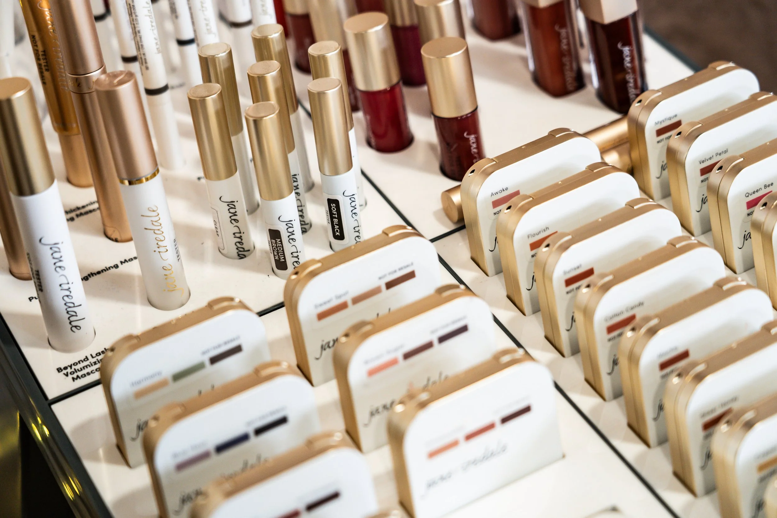Display of various makeup products including lipsticks and eyeshadows arranged neatly on a white surface.