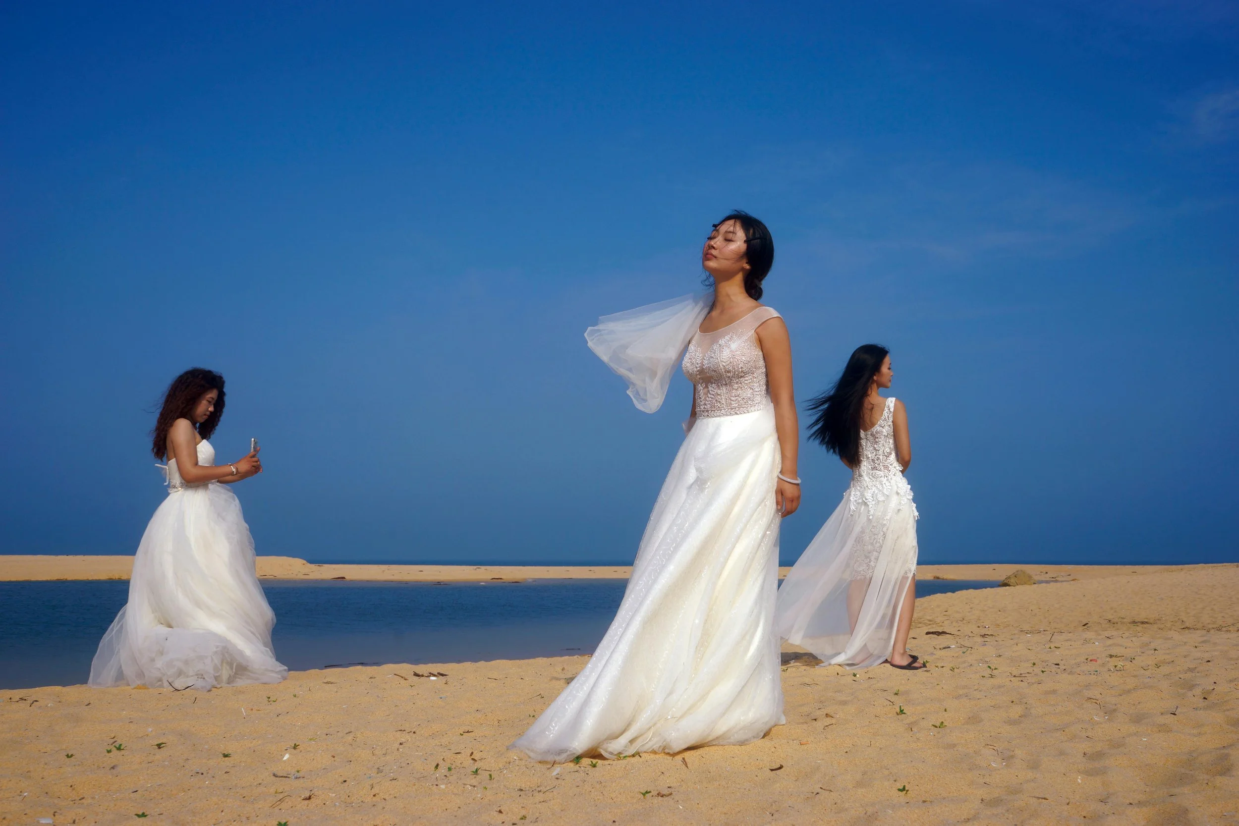 mujeres usando vestido de novia en la playa