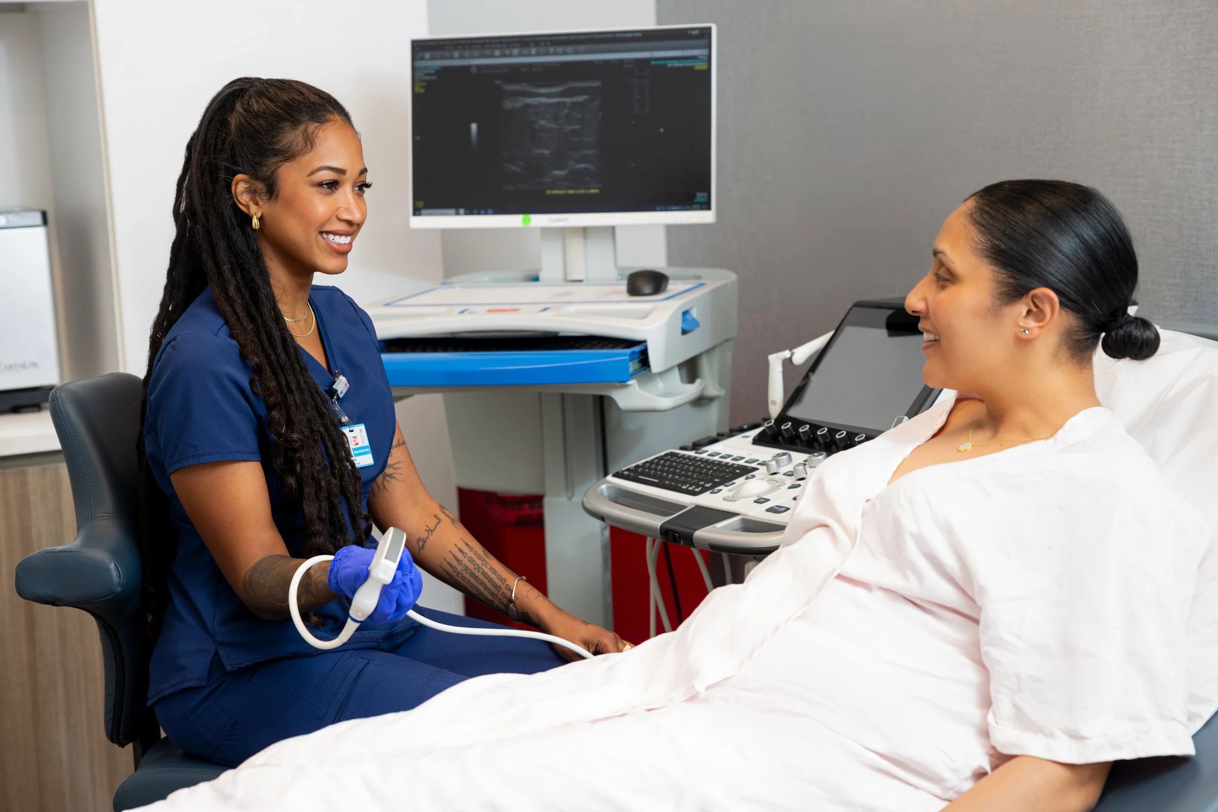 Female patient having an ultrasound with a smiling technician.
