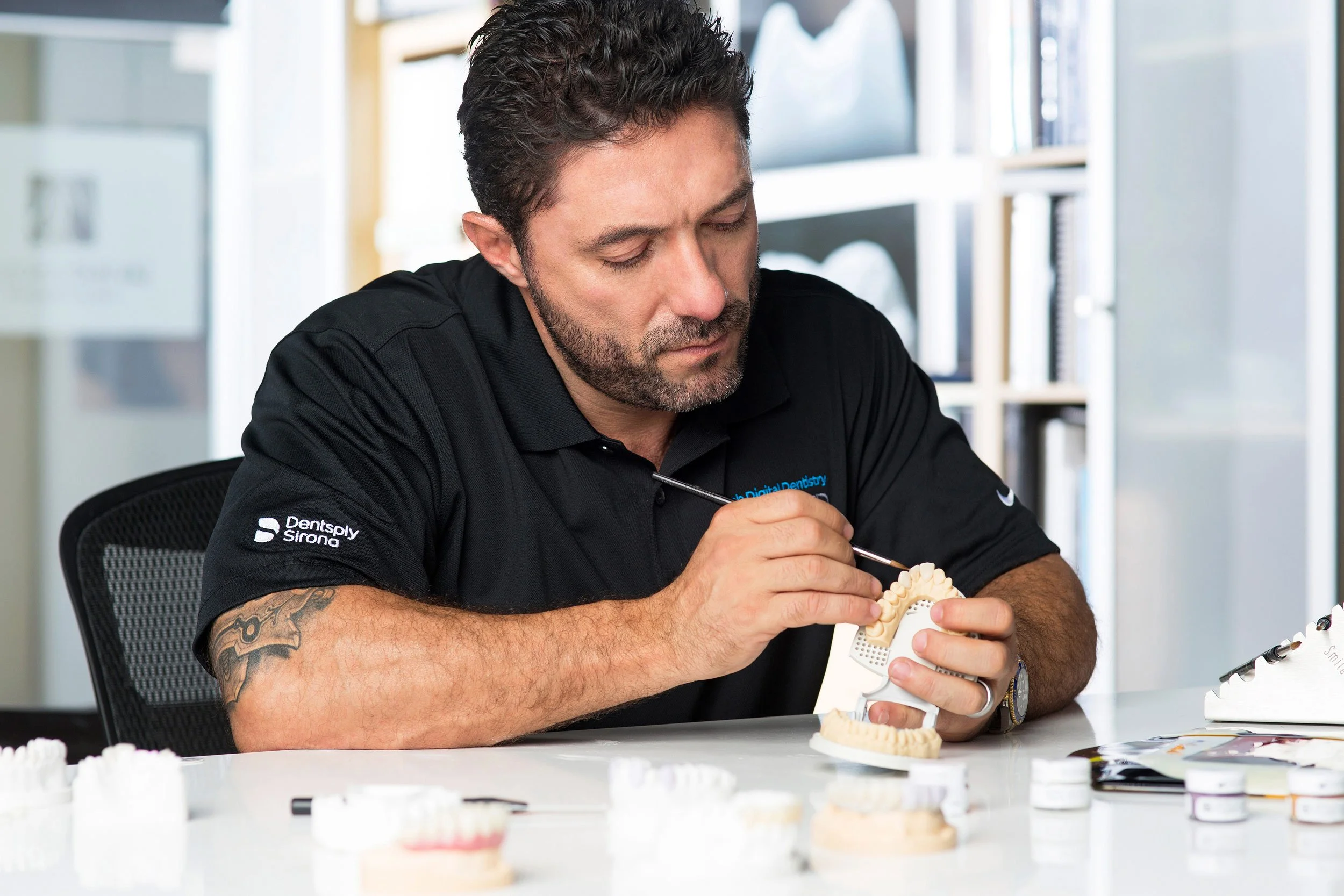 Male dental technician crafting a mold in a bright studio.