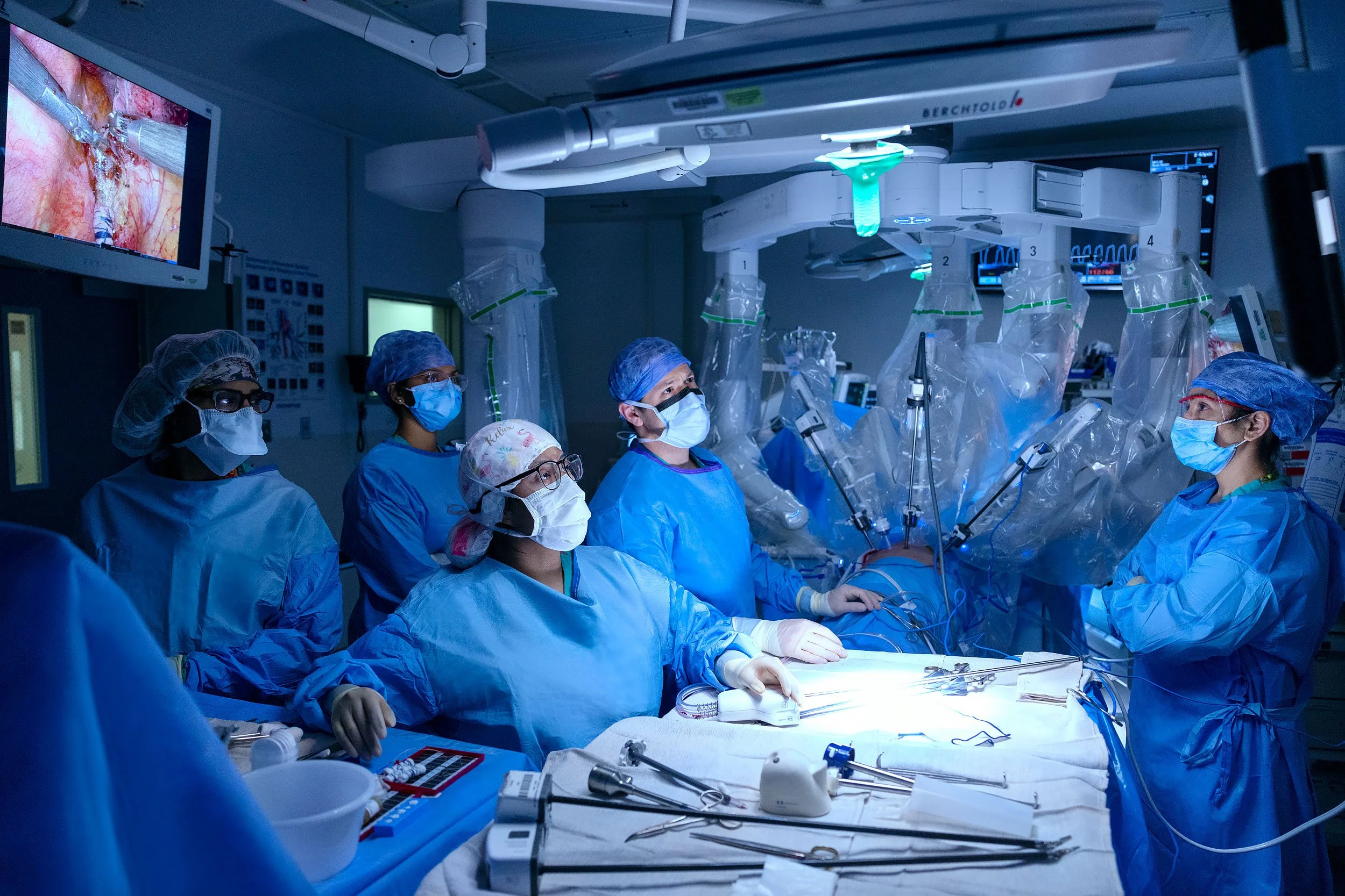 Team of surgeons using robotic arm technology in the operating room.