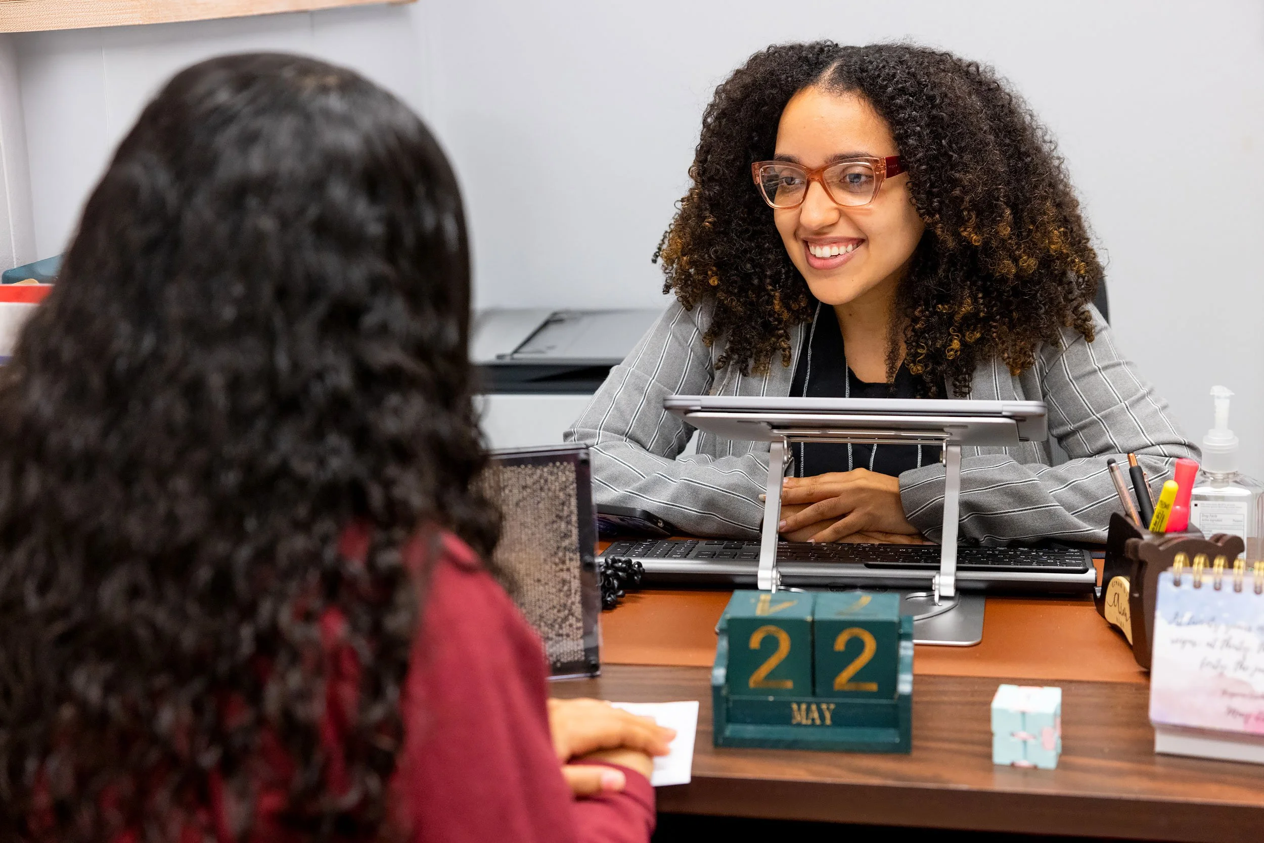 School counselor smiling at student during a conversation in her office. 