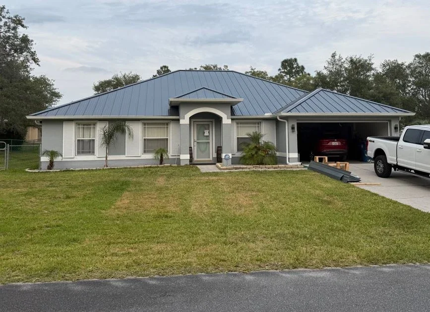 Completed blue metal roof installation on a single-story home in Brooksville, FL by Craig Fass Roofing.