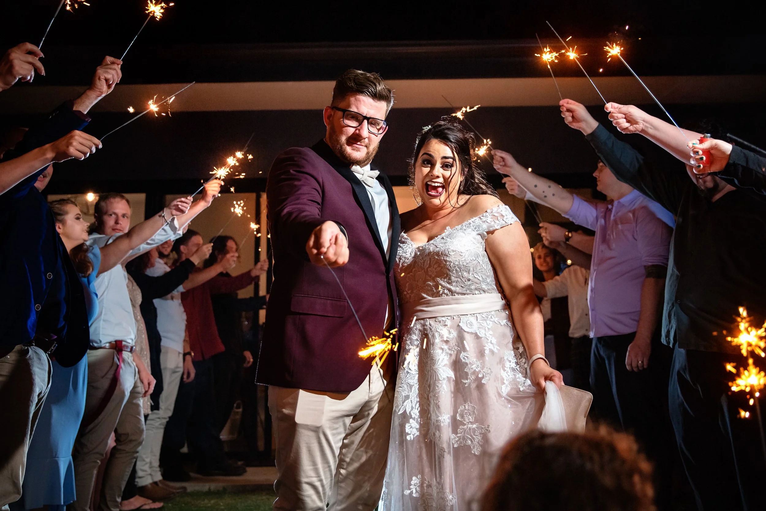 A newlywed couple celebrating with a sparkler exit surrounded by guests at their Hunter Valley wedding.