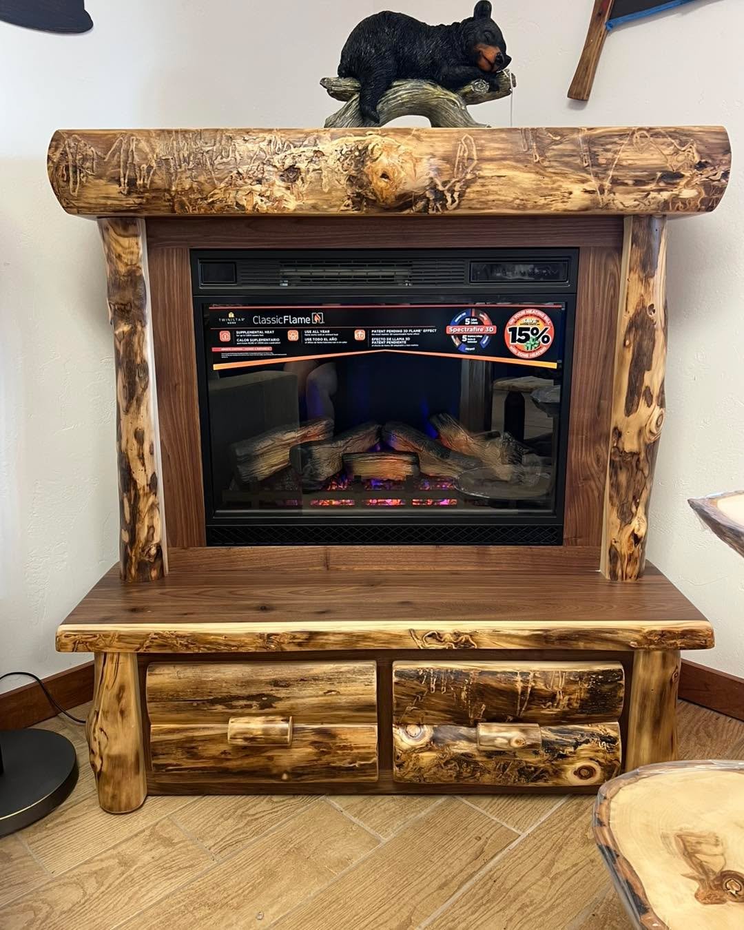 A perfect Father&rsquo;s Day gift!! It&rsquo;s a corner fireplace with two drawers.  The front is made of dark walnut and aspen log for character.  The fireplace changes colors, speed, blows heat and has a remote.  Amish made item.  On sale till Fath