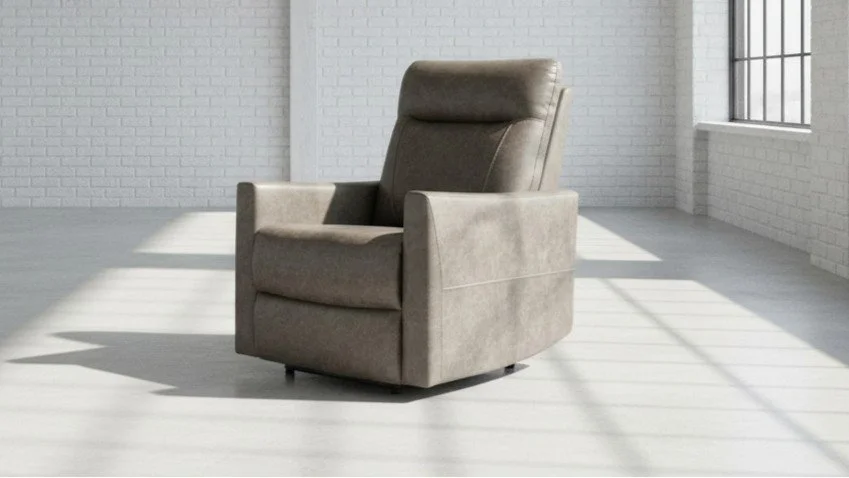 A beige upholstered armchair in a bright, empty room with white brick walls and large windows, casting shadows on the light-colored wooden floor.