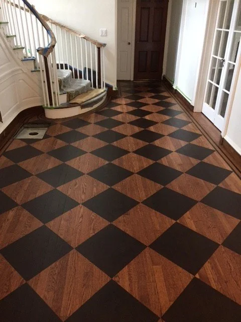 Hallway with a wooden checkered floor, spiral staircase, and white walls.Home show kitchen floors checkerboard faux painted floor venetian plaster metallic designer finishes paint glazes 