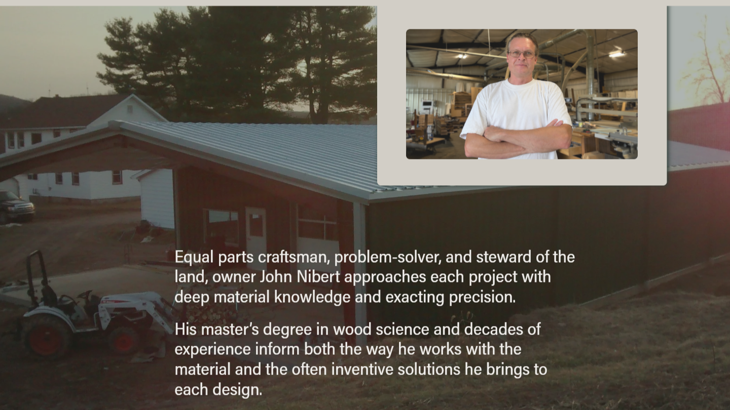 A construction site with an unfinished building, a tractor, and outdoor trees in the background. An inset shows a man standing with crossed arms inside a workshop with wood and machinery. Overlaid text describes owner John Nibert's expertise in woodworking, problem-solving, and material knowledge.