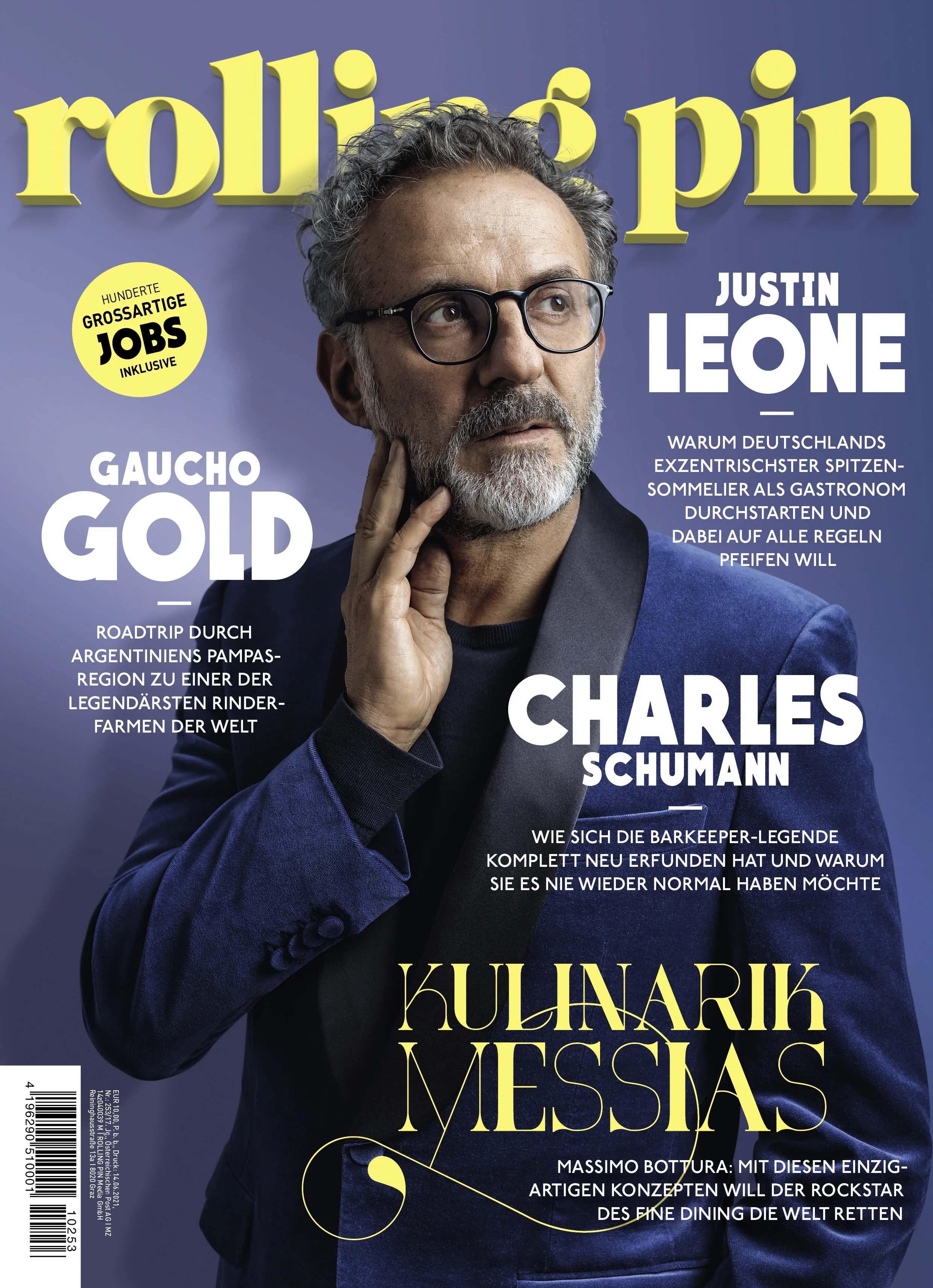 Cover eines Magazins mit einem Mann mit Brille und grauem Bart, der ein dunkles Blazer trägt, vor einem blauen Hintergrund. Der Text auf dem Cover beinhaltet Namen und Themen, wie Justin Leone, Charles Schumann, Kulinarik und Messi.