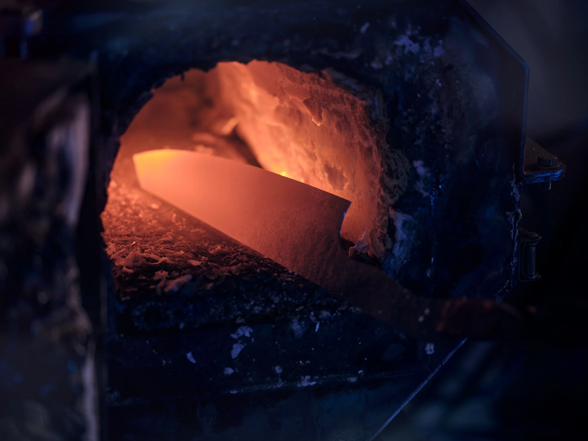 Heißes Metall wird in einem Ofen erhitzt. Der glühende Metallblock leuchtet orange.