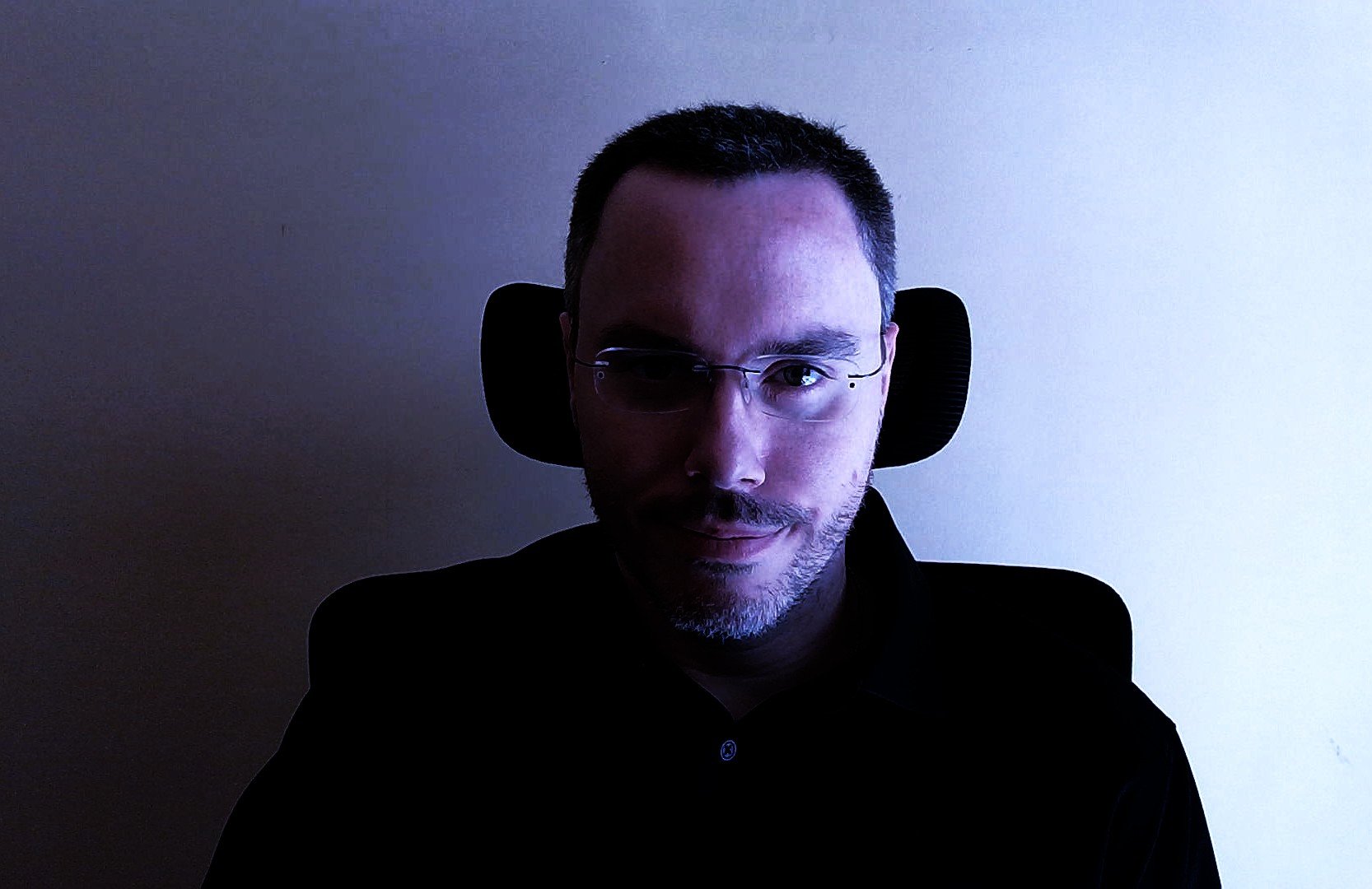 Black-and-white portrait of a young woman with long hair, her eyes closed, and hands placed on her temples, appearing to be in distress or deep thought.