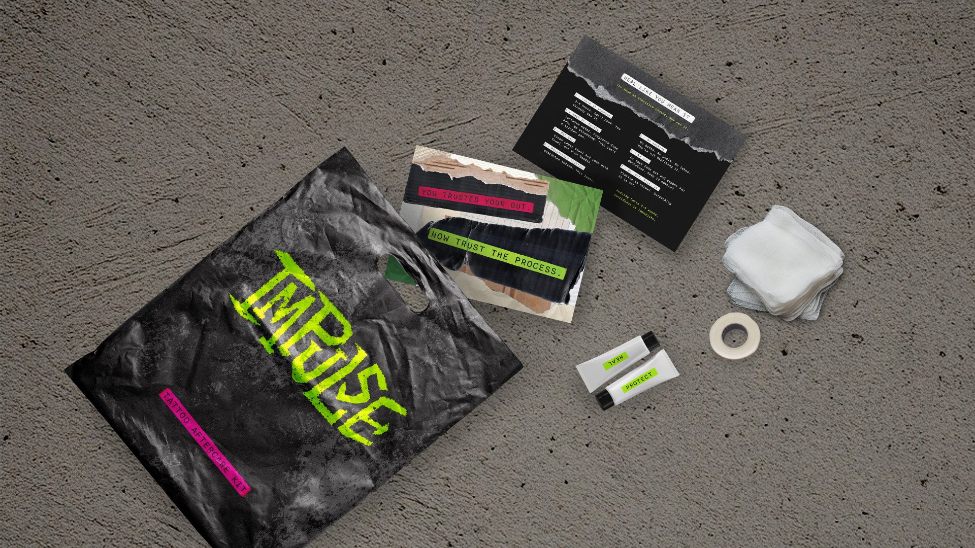 Tattoo aftercare kit with a black bag labeled 'Tattoo Aftercare Kit', a roll of medical tape, a pair of white gloves, small tubes labeled 'Heal' and 'Protect', a small jar, and printed instructions on how to heal a tattoo.