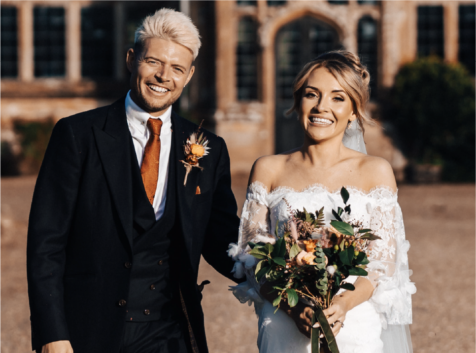 Bride and groom celebrating at their wedding, surrounded by guests, as confetti is thrown in the air.