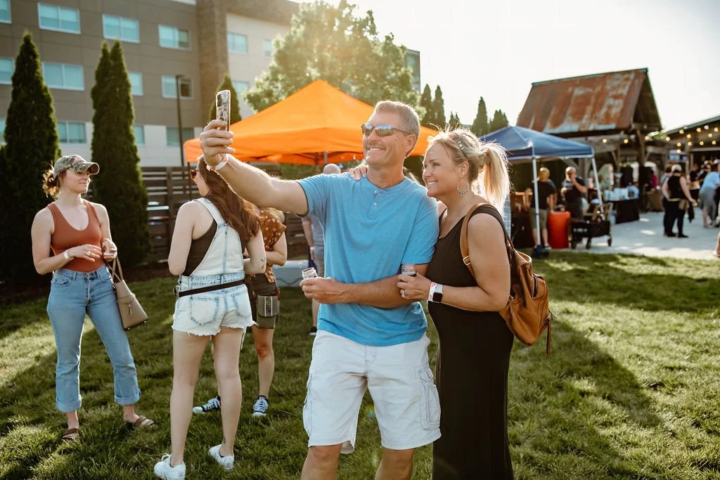 Laurie’s customers, Mariana and Carmen holding hands on a green lawn on their wedding day.