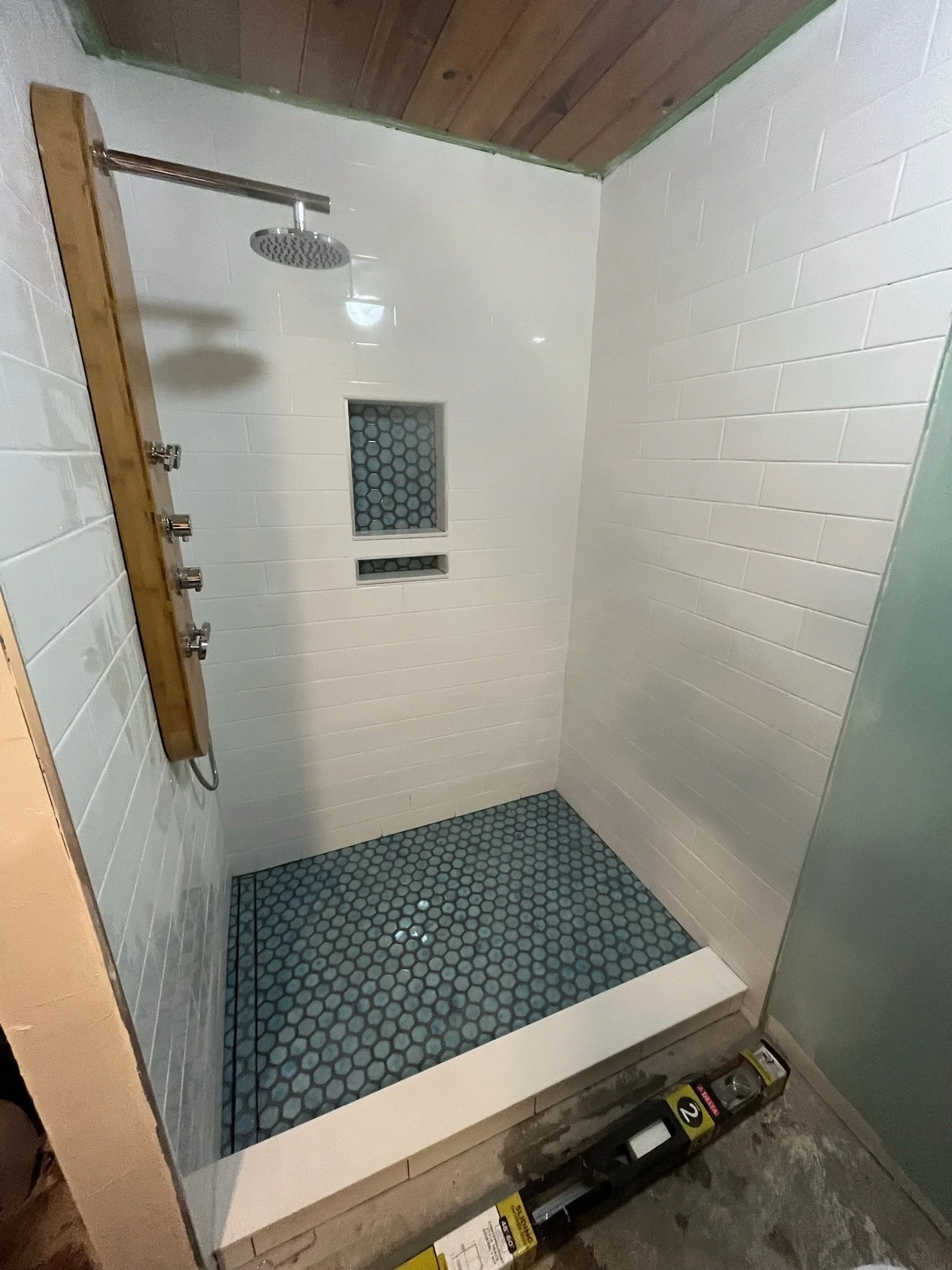 custom walk in shower renovation Dayton Ohio white tile shower with blue hex tile floor and niche