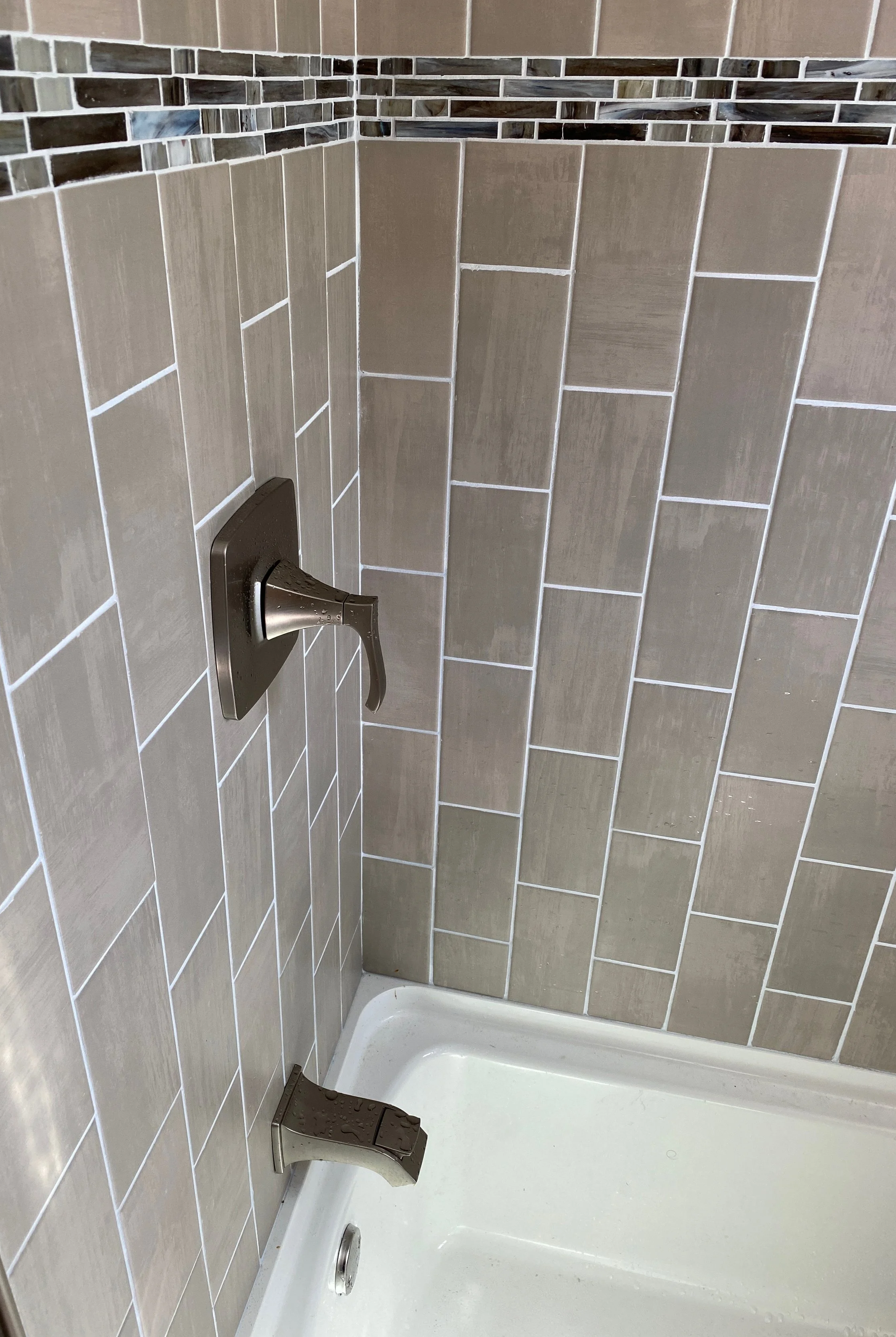 tile shower accent strip Dayton Ohio custom bathroom remodel mosaic detail band